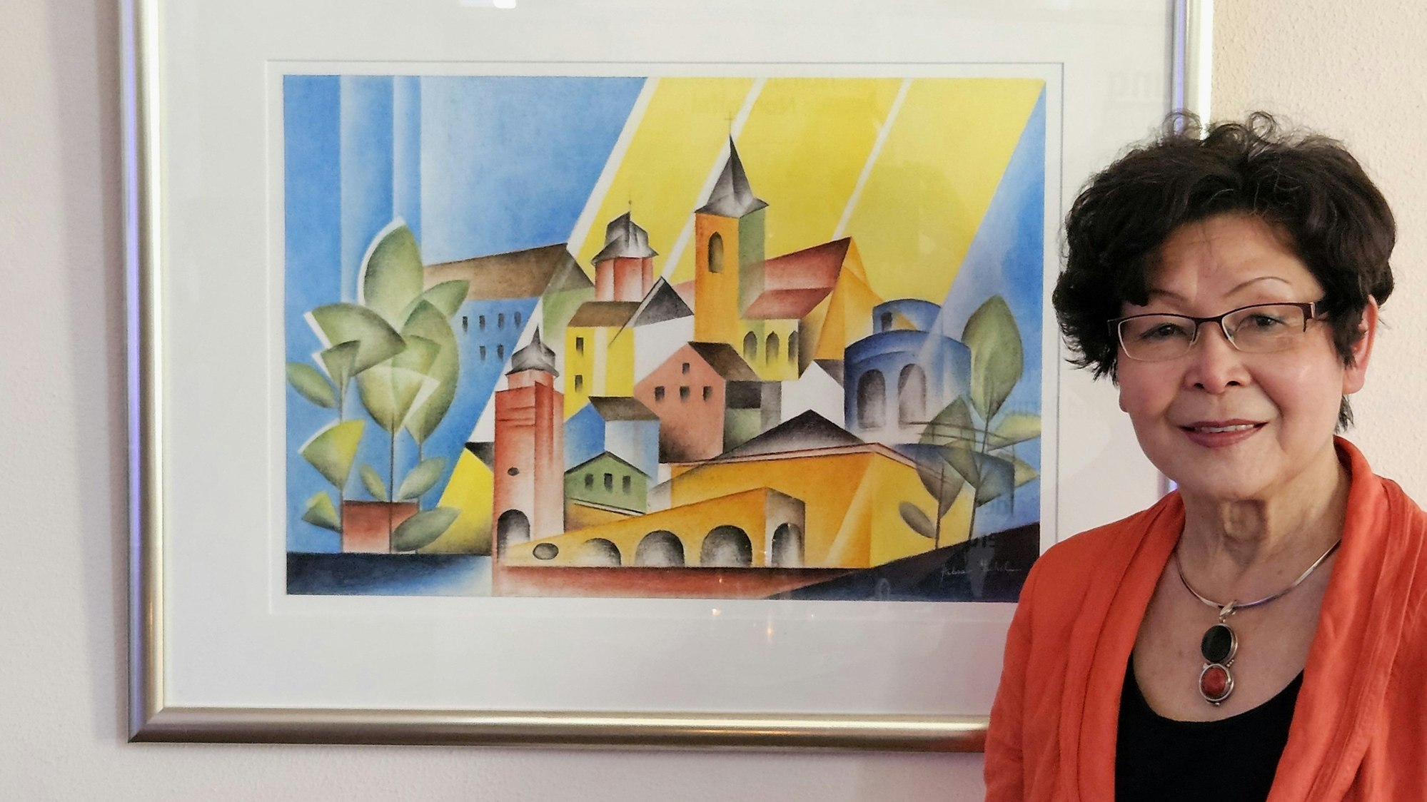 Die Künstlerin steht neben ihrem Bild.