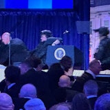 US-Präsident Donald Trump (l) sitzt auf der Bühne, während Agenten des US-Geheimdienstes ihn nach einem Vorfall außerhalb des Ballsaals während des White House Correspondents' Dinner aus dem Ballsaal bringen.