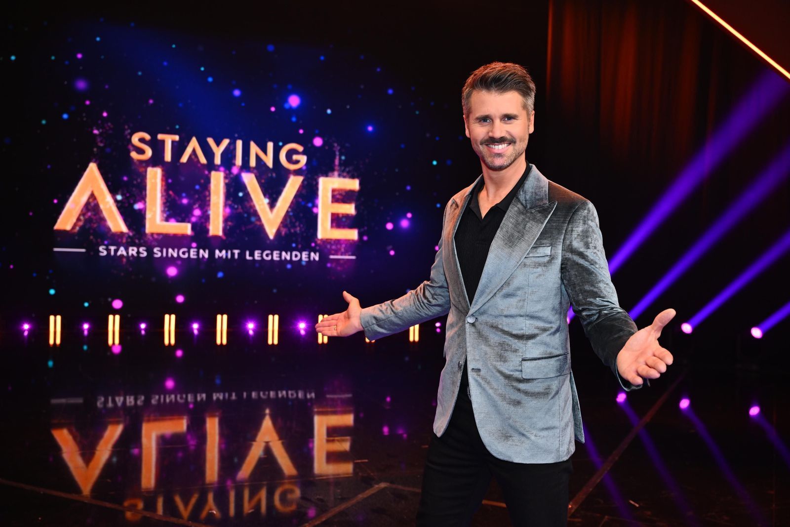 Moderator Thore Schölermann fragt den Fake-Elvis, ob dieser an Lampenfieber leide. (Bild: Joyn / Julia Feldhagen)