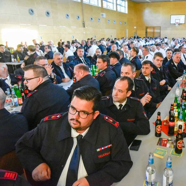 Auf dem Bild sind Teilnehmer der Delegiertenversammlung in Uniform an langen Tischen zu sehen.