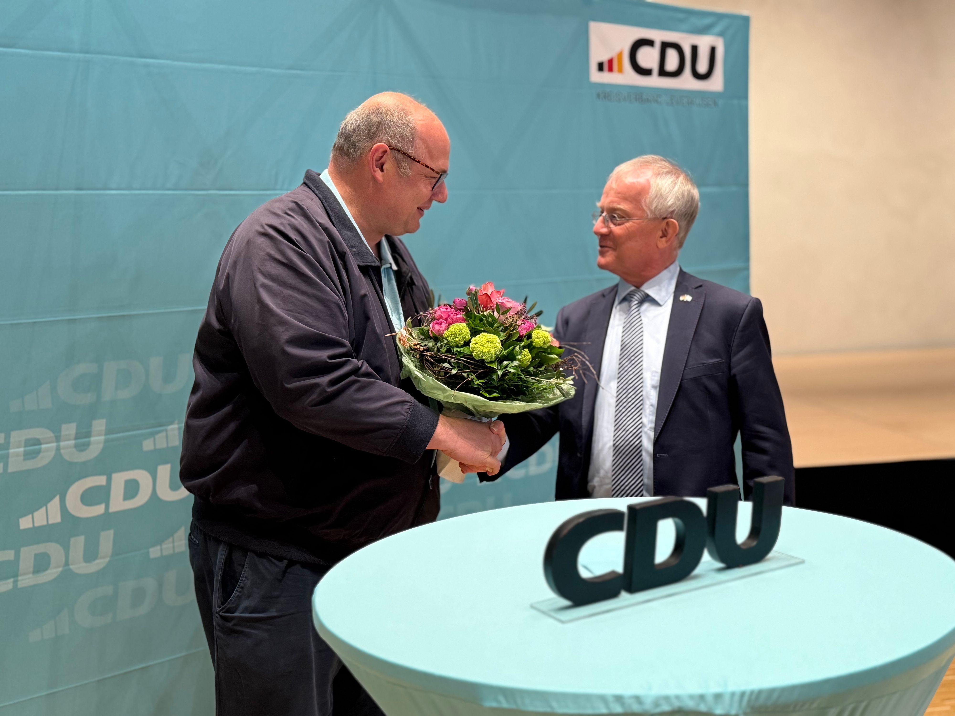 Stefan Hebbel überreicht Rüdiger Scholz einen Blumenstrauß.