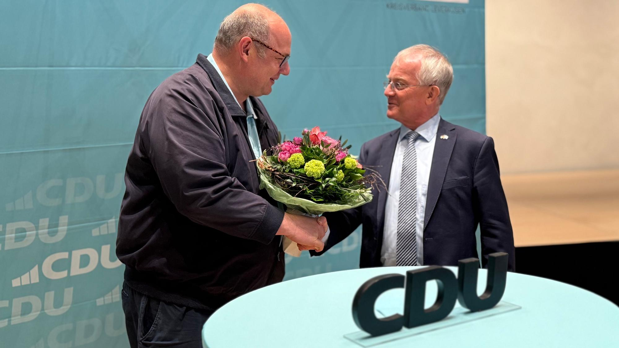 Stefan Hebbel überreicht Rüdiger Scholz einen Blumenstrauß.