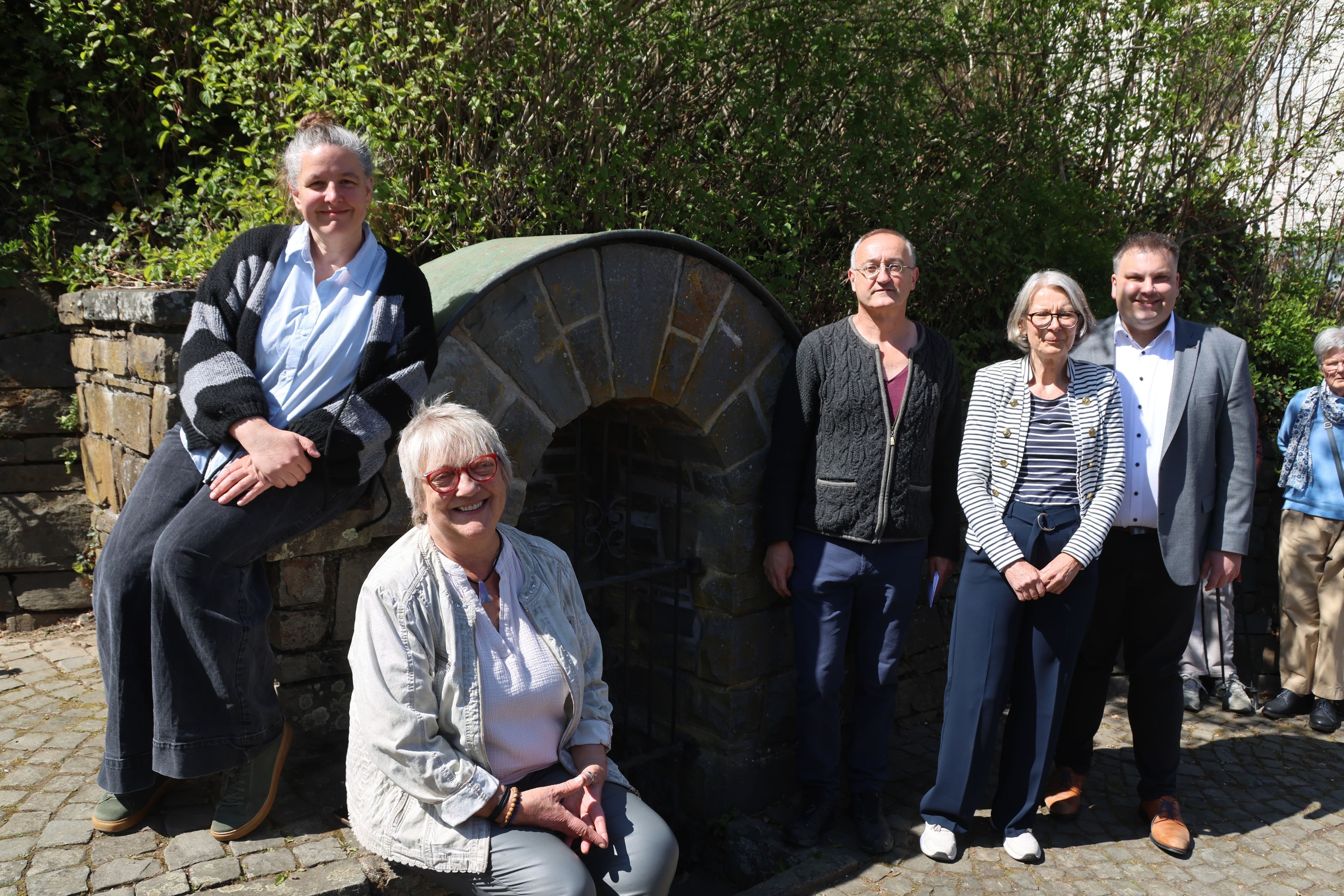 Eine Gruppe positer an einem Brunnen.