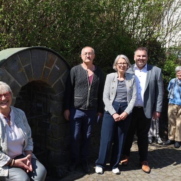 Eine Gruppe positer an einem Brunnen.