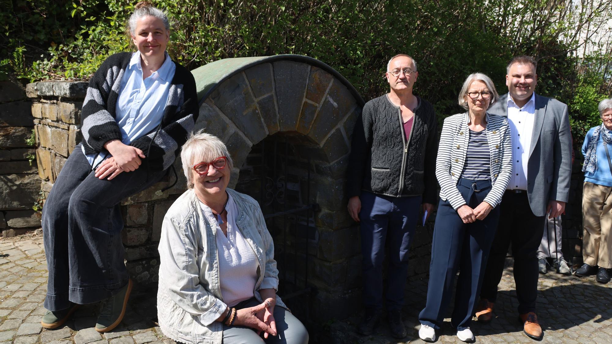 Eine Gruppe positer an einem Brunnen.