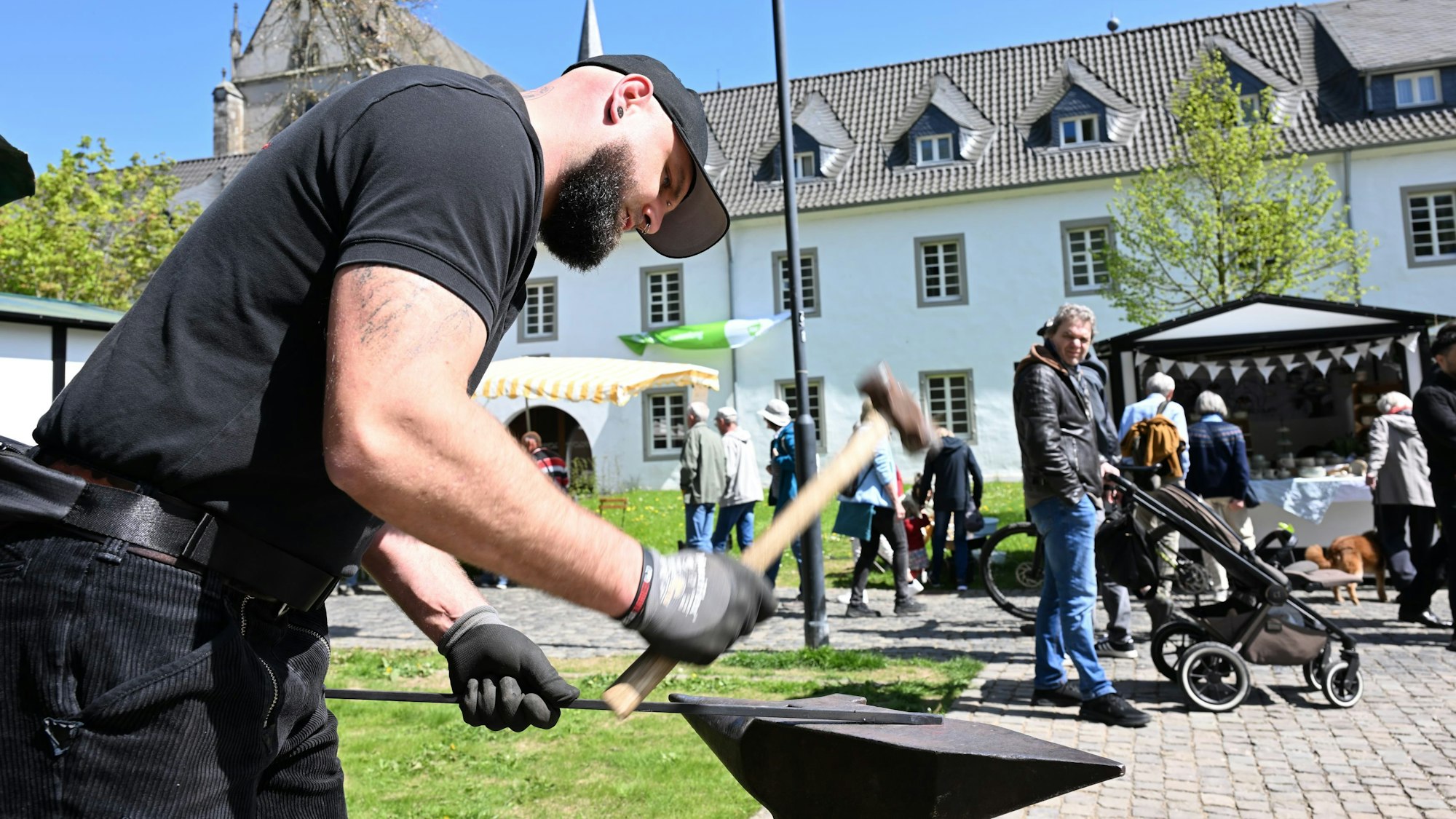 Ein Schmied hat mit einem Hammer auf ein Stück Eisen.