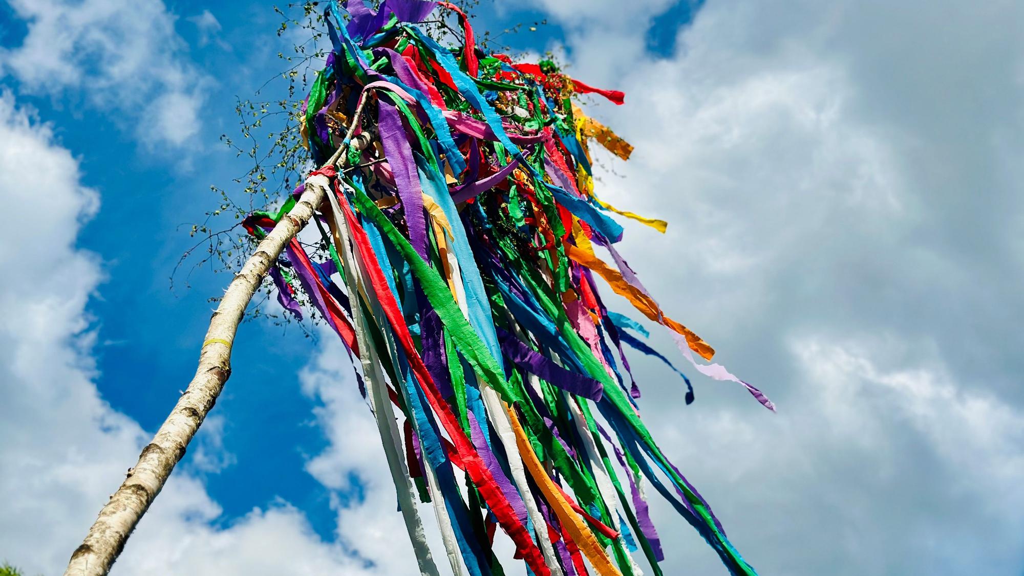 Auf dem Bild ist ein bunt geschmückter Maibaum zu sehen.