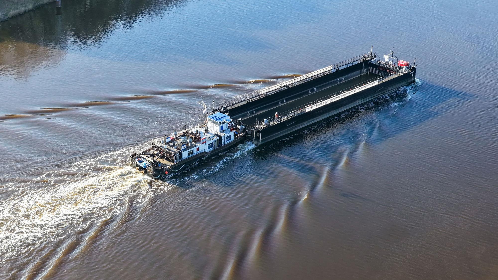 Ein Lastkahn, geschoben von dem Schubschiff „Hans“ fährt auf dem Nord-Ostsee-Kanal bei Hohenhörn.