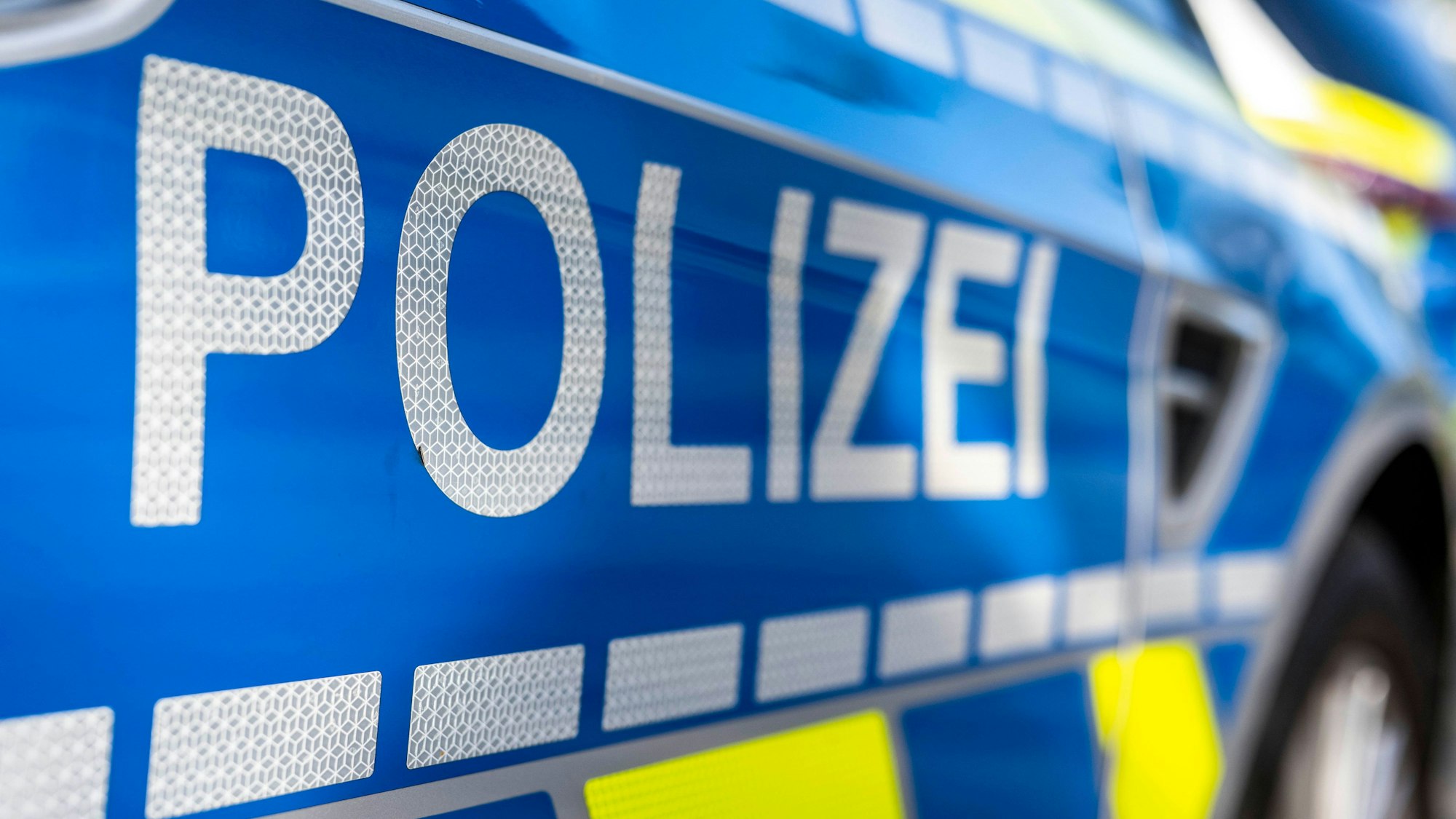 ILLUSTRATION - 28.09.2021, Nordrhein-Westfalen, Gütersloh: An der Tür von einem Streifenwagen steht der Schriftzug «Polizei». Ein Unbekannter soll einen Gegenstand von einer Autobahnbrücke bei Regensburg auf ein darunter fahrendes Auto geworfen haben. (zu dpa: «Gegenstand von Brücke auf Auto geworfen – Scheibe zerbricht») Foto: David Inderlied/dpa +++ dpa-Bildfunk +++
