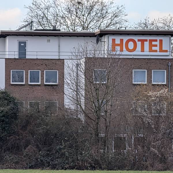 Das Foto zeigt eine Außenaufnahme eines Gebäudes mit großem Schriftzug „Hotel“.