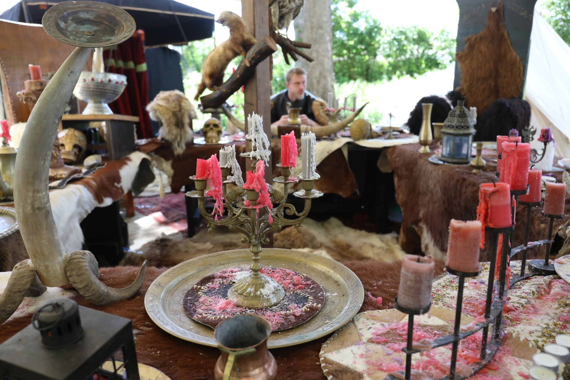 Tische mit Kerzenständern, Bechern und Schalen sowie Fellen als Tischdecke.