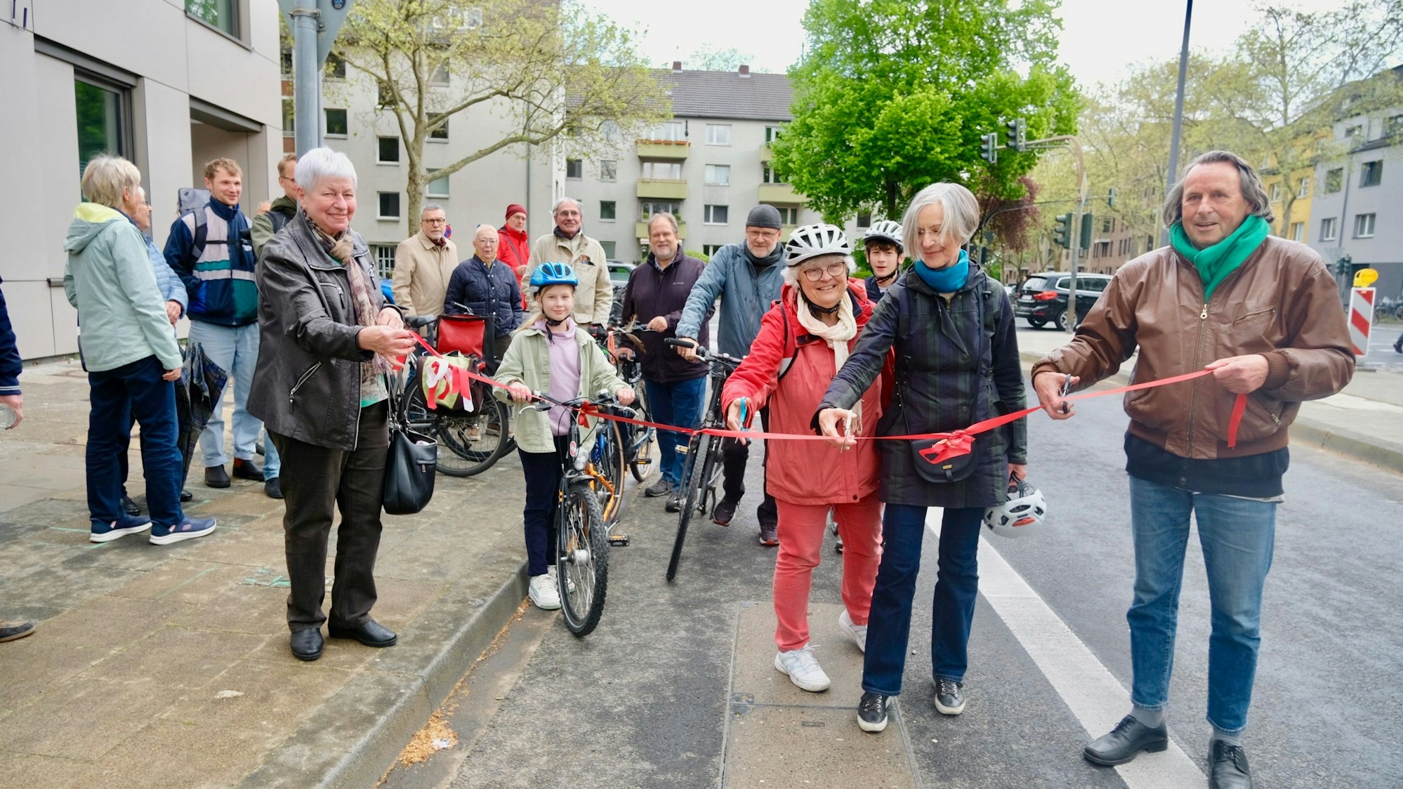 Hille Lammers (v.l.), die ehemalige Bezirksbürgermeisterin Cornelia Weitekamp (Grüne) und Bezirksbürgermeister Roland Schüler (Grüne) durchtrennen das rote Band. Barbara Albat (SPD, l.) hilft beim Halten.