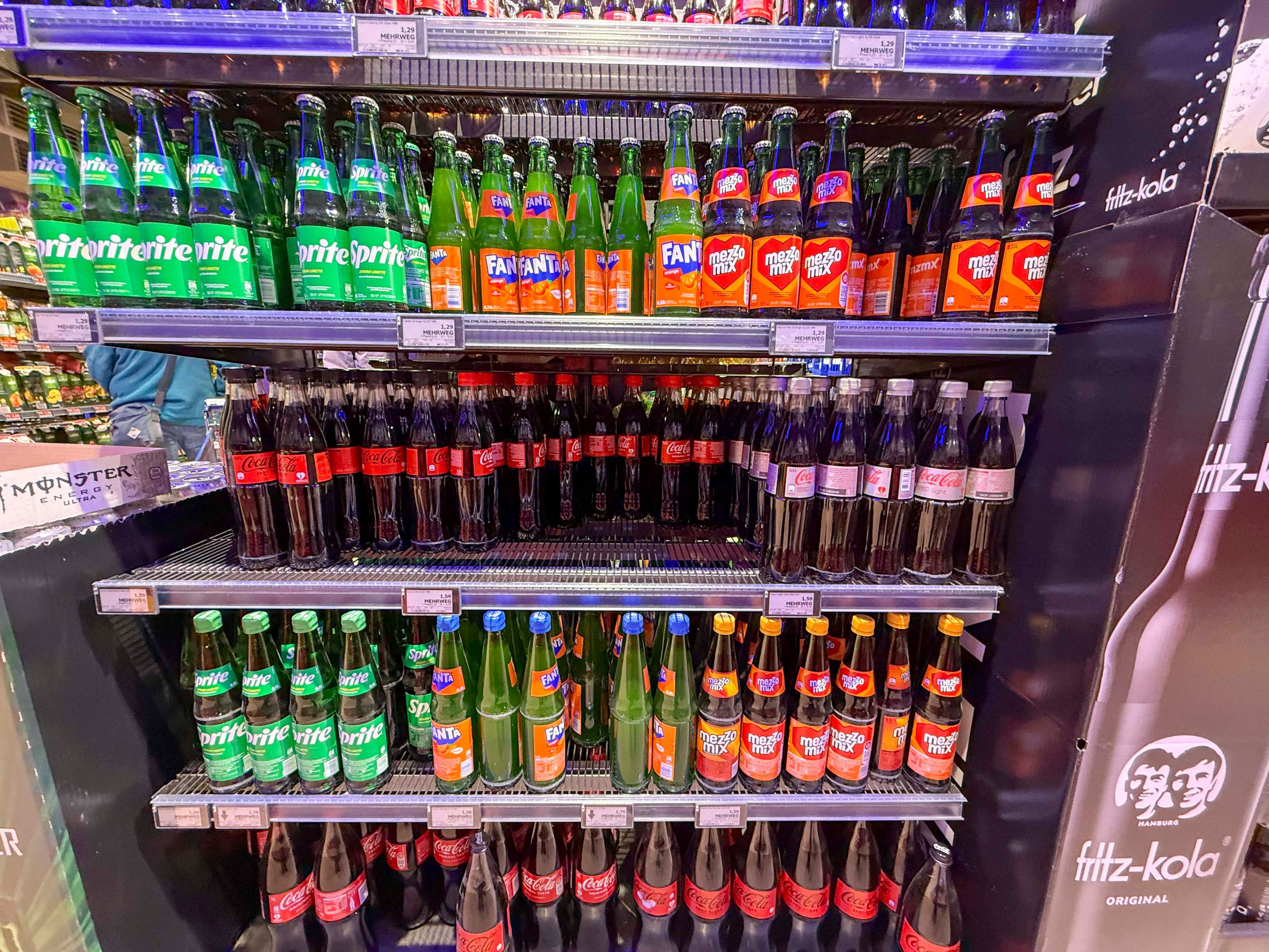 Regal mit Coca Cola Sprite Fanta Plastik Einwegflaschen im Getraenkemarkt zum Verkauf.