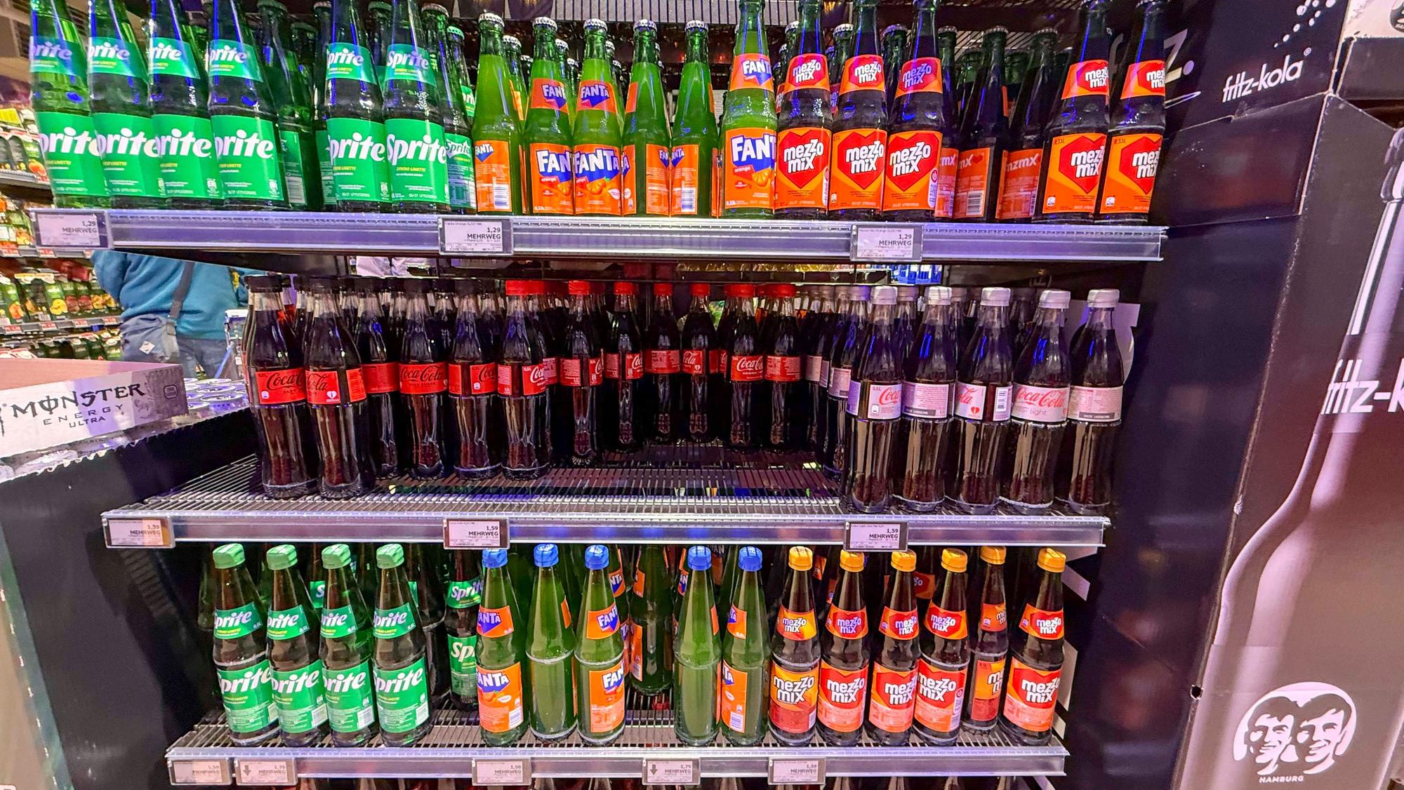 Regal mit Coca Cola Sprite Fanta Plastik Einwegflaschen im Getraenkemarkt zum Verkauf.