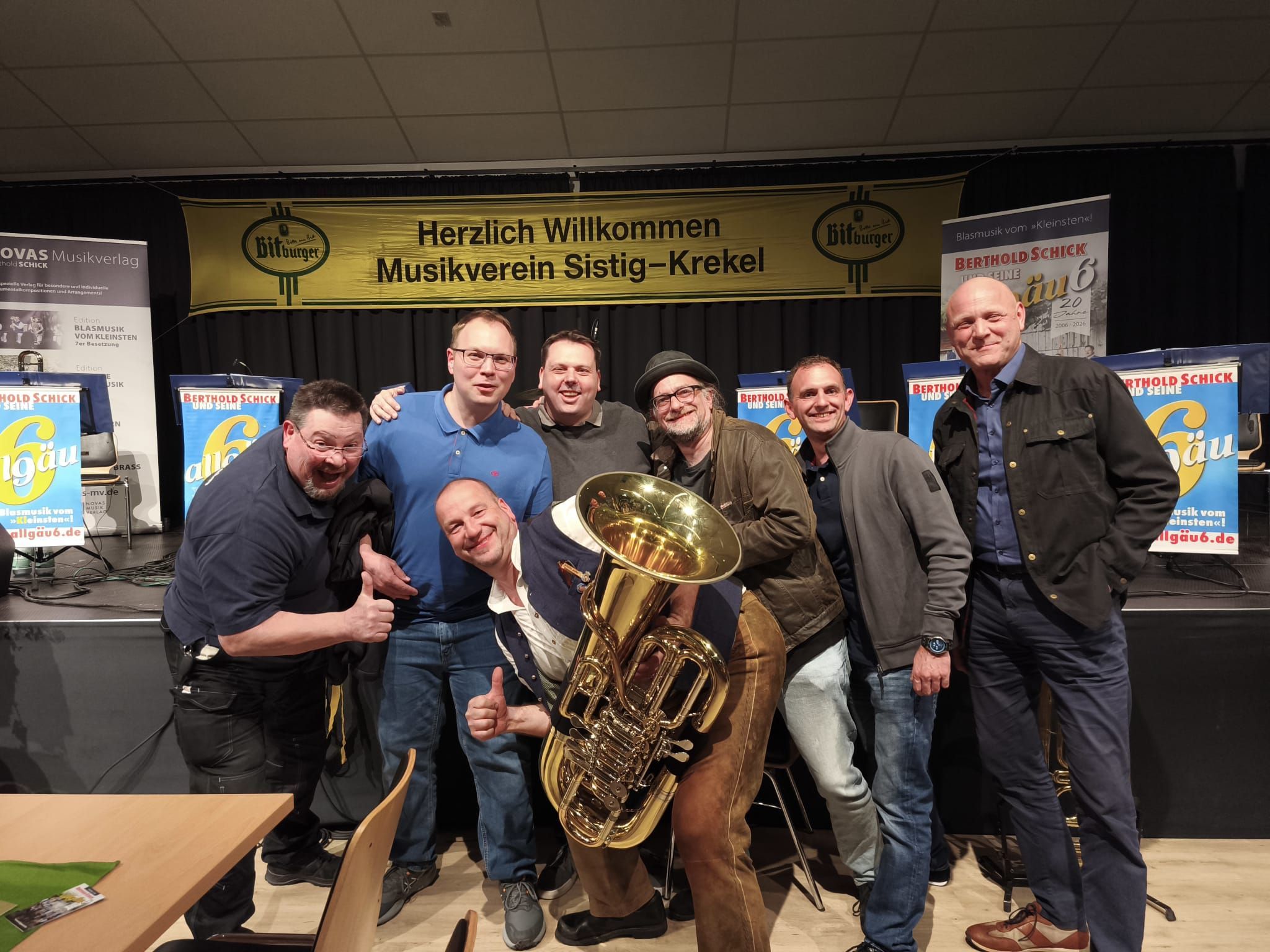 Das Foto zeigt die Bandmitglieder, einer hält eine Tuba.