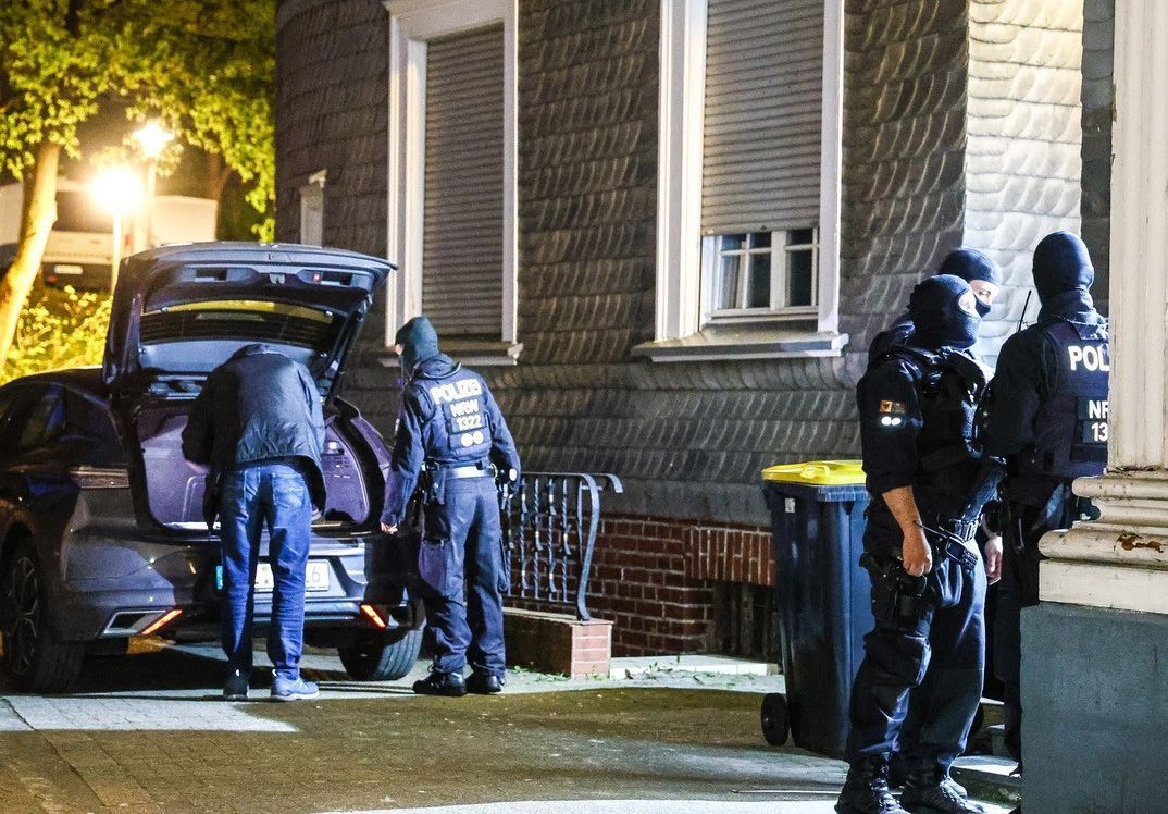 Das Bild zeigt vermummte Polizisten vor einem Haus.