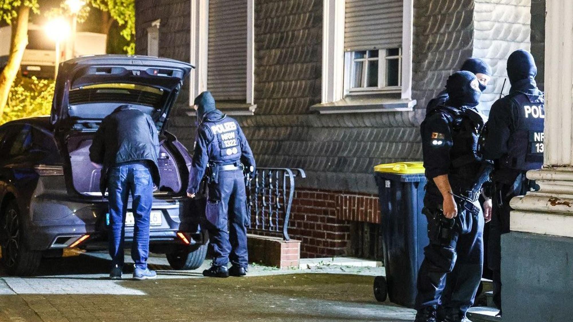 Das Bild zeigt vermummte Polizisten vor einem Haus.