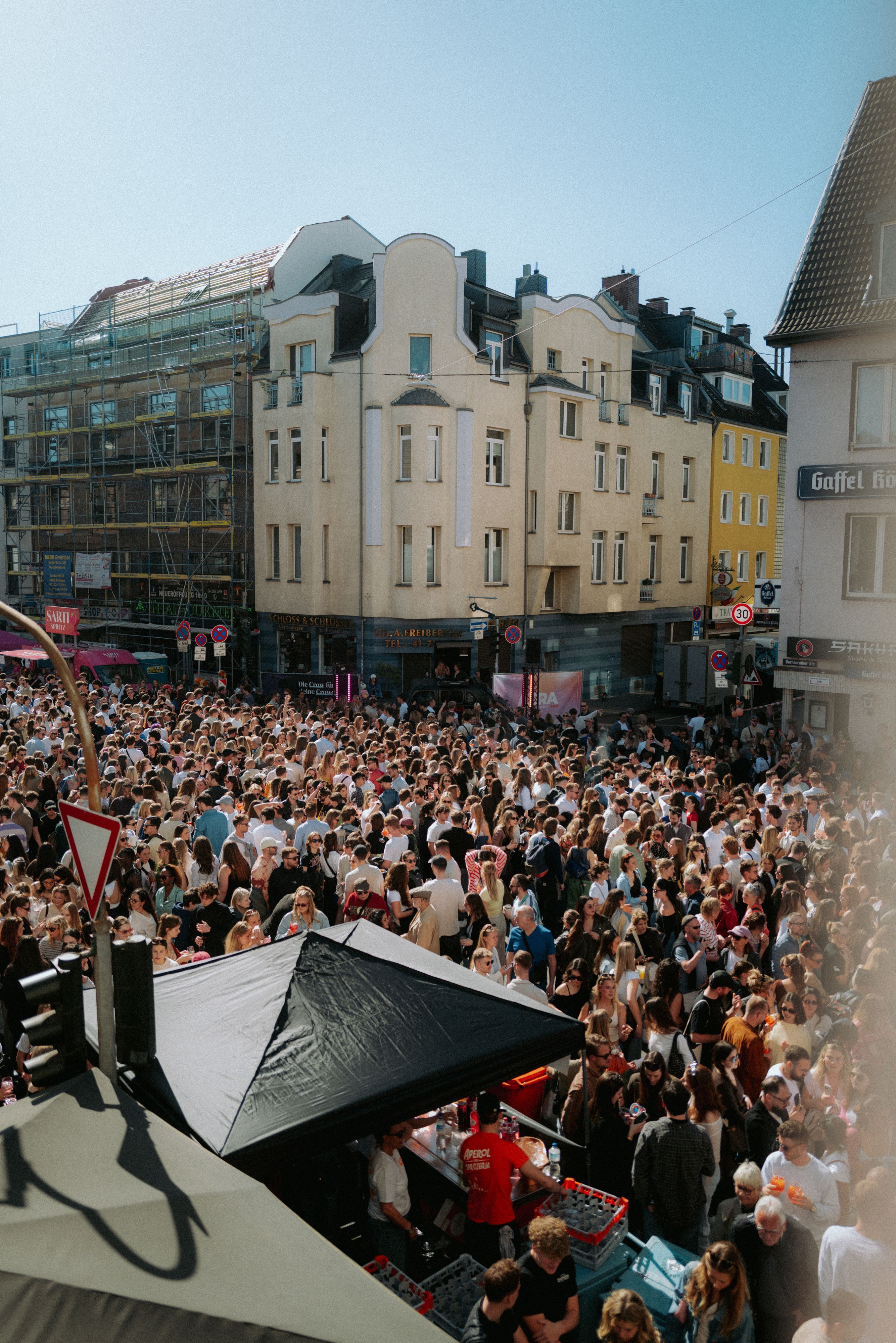 Viele Menschen stehen auf einer Straße.