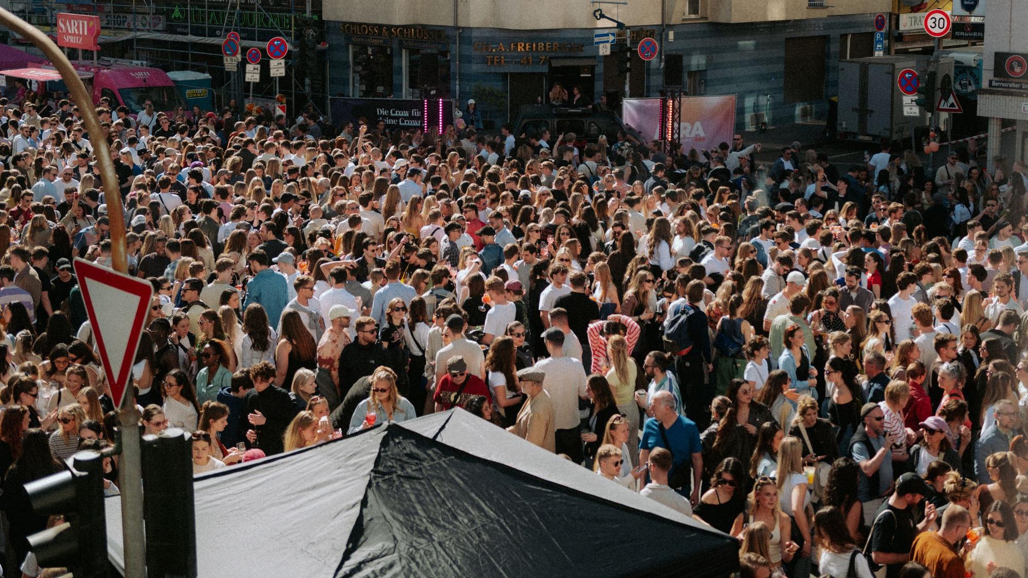 Viele Menschen stehen auf einer Straße.