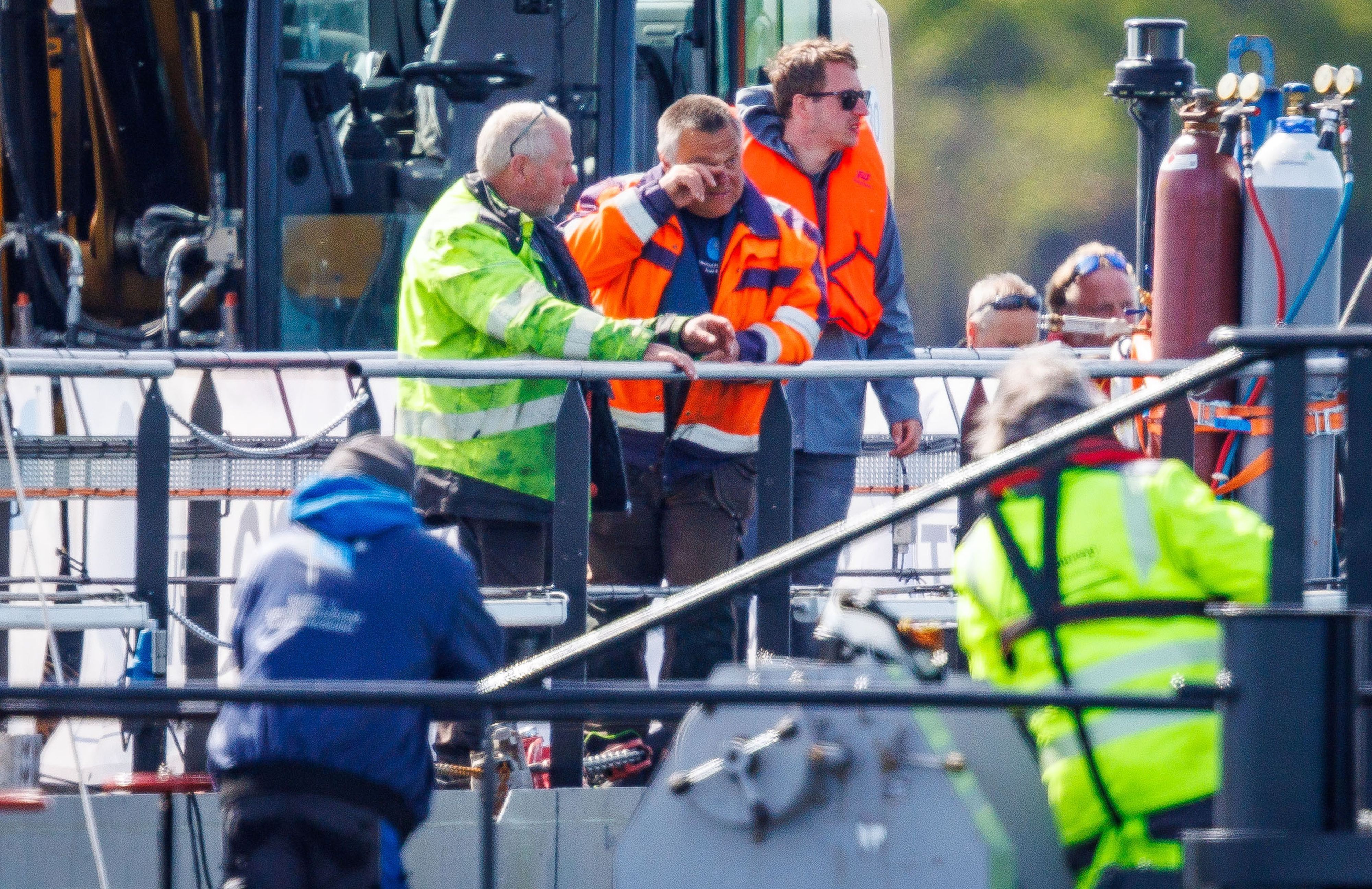 Tauchunternehmer Fred Babbel (M) feiert auf dem Transportschiff, nachdem der gestrandete Buckelwal vor der Insel Poel mit Gurten in den Lastkahn gezogen wurde.