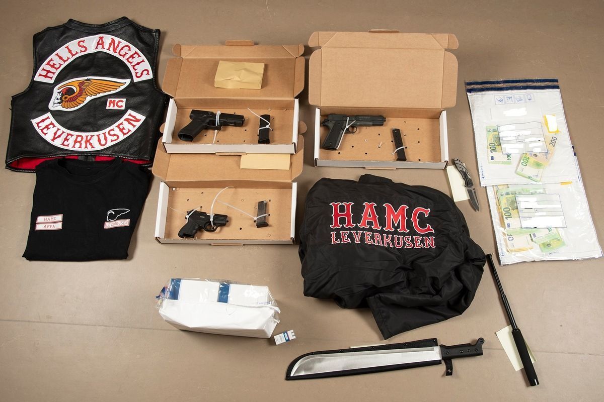 Sichergestellte Gegenstände und Bargeld liegen auf einem Tisch. Bei den Razzien gegen Hells Angels-Rocker in Nordrhein-Westfalen haben die Ermittlungsbehörden unter anderem Waffen und Vermögenswerte sichergestellt.