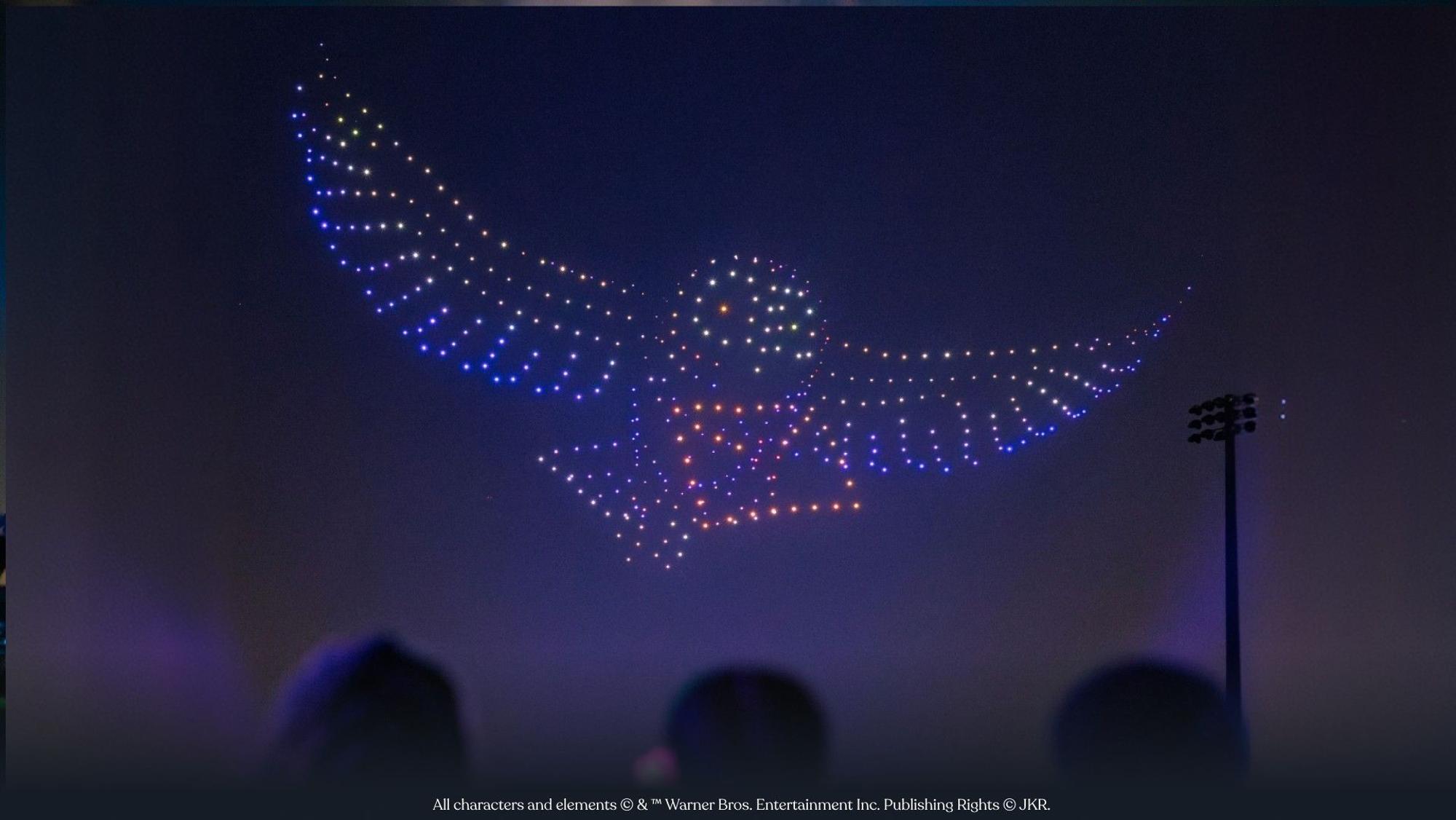 Leuchtende Drohnen bilden am Himmel eine Eule wie aus den Harry-Potter-Filmen.