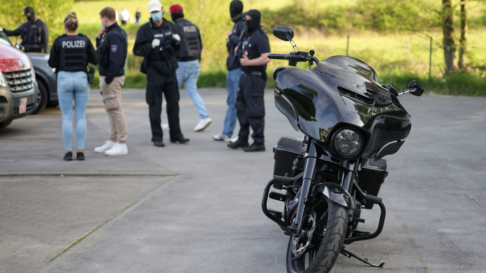 Ein Motorrad der Marke Harley Davidson, das im Rahmen einer Razzia gegen die Rockergruppe Hells Angels von der Polizei beschlagnahmt wurde, steht vor einem Haus.