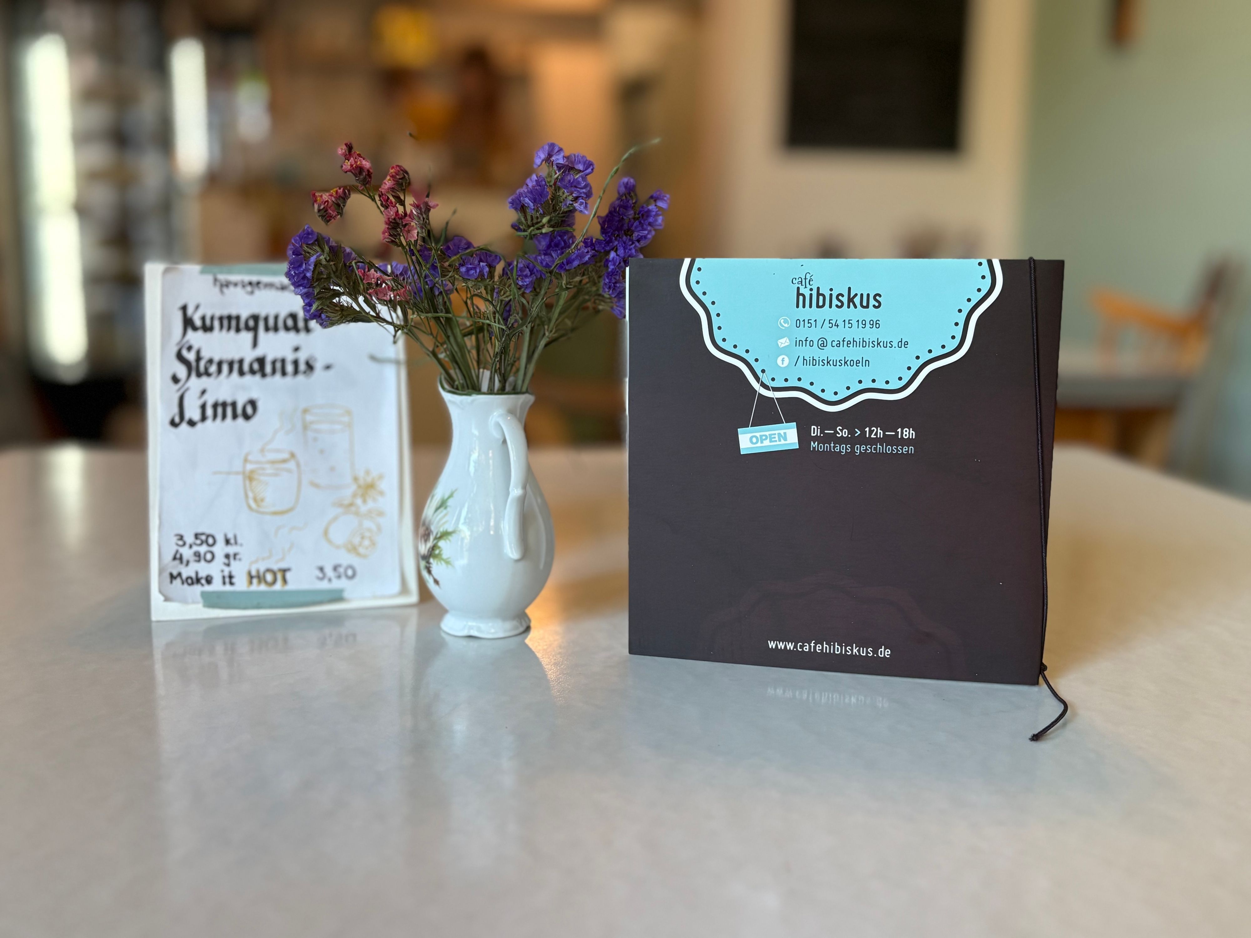 Karte und Blumen auf einem Tisch im Café Hibiskus.