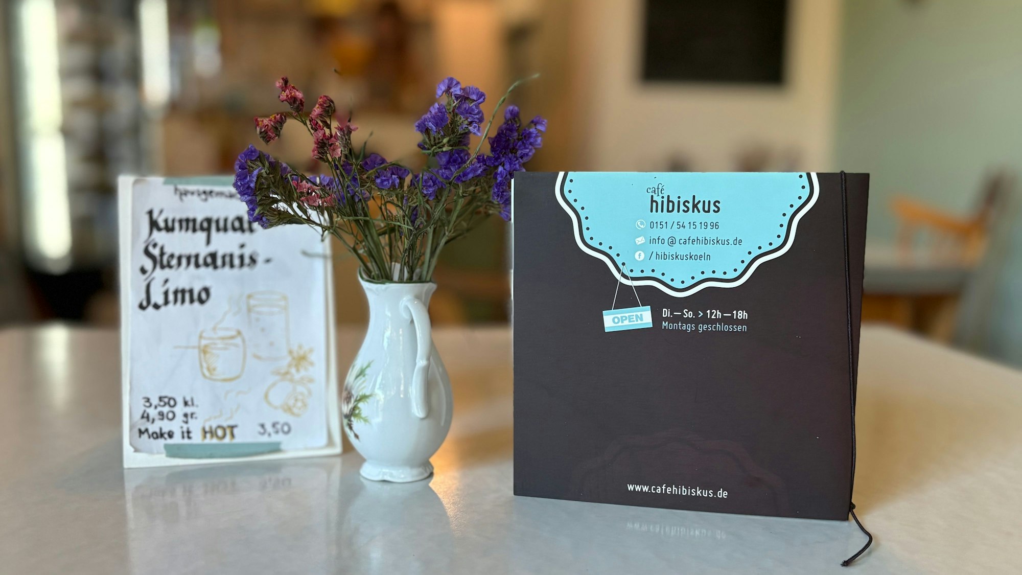 Karte und Blumen auf einem Tisch im Café Hibiskus.