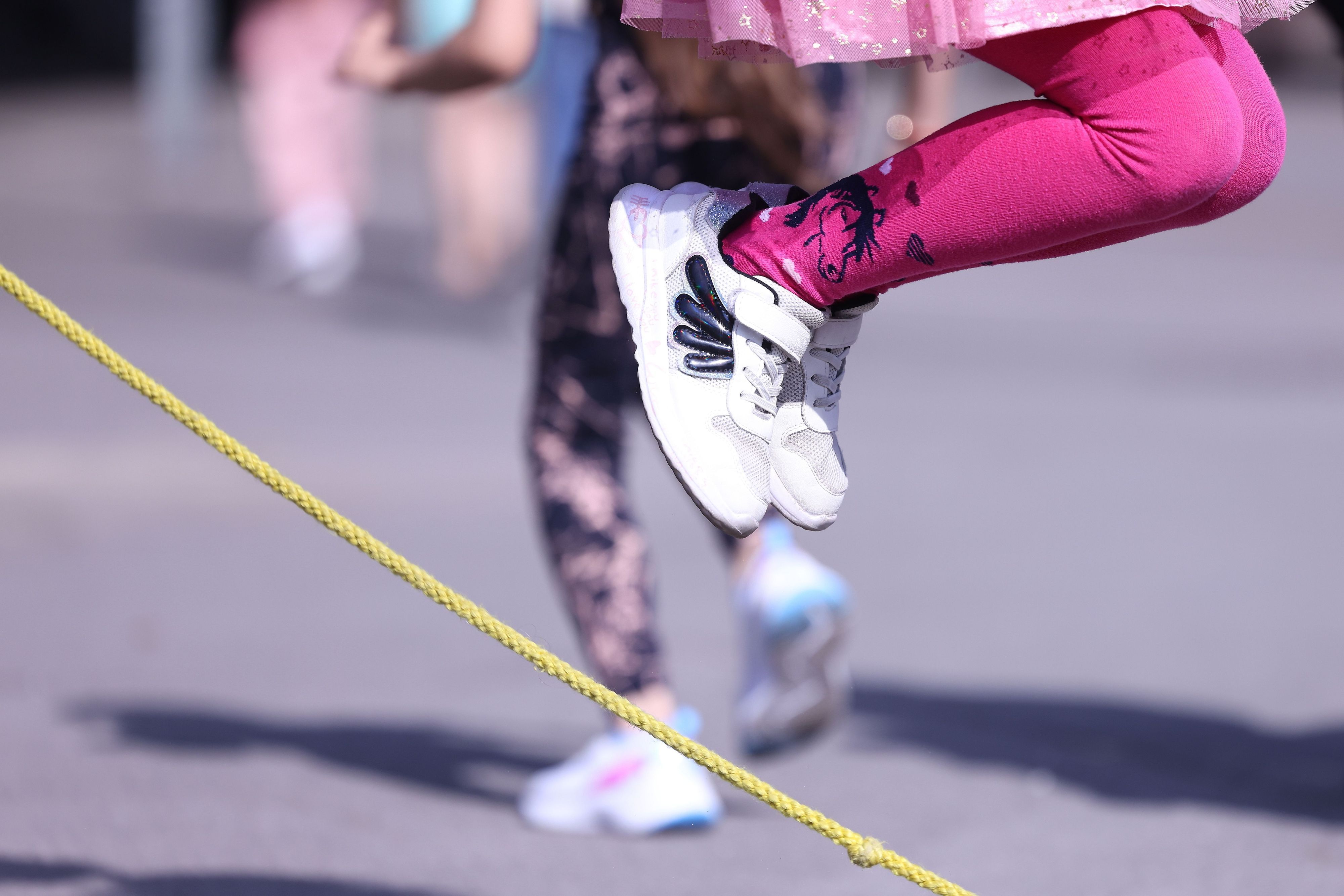 Ein Kind springt über ein Seil auf einem Schulhof.