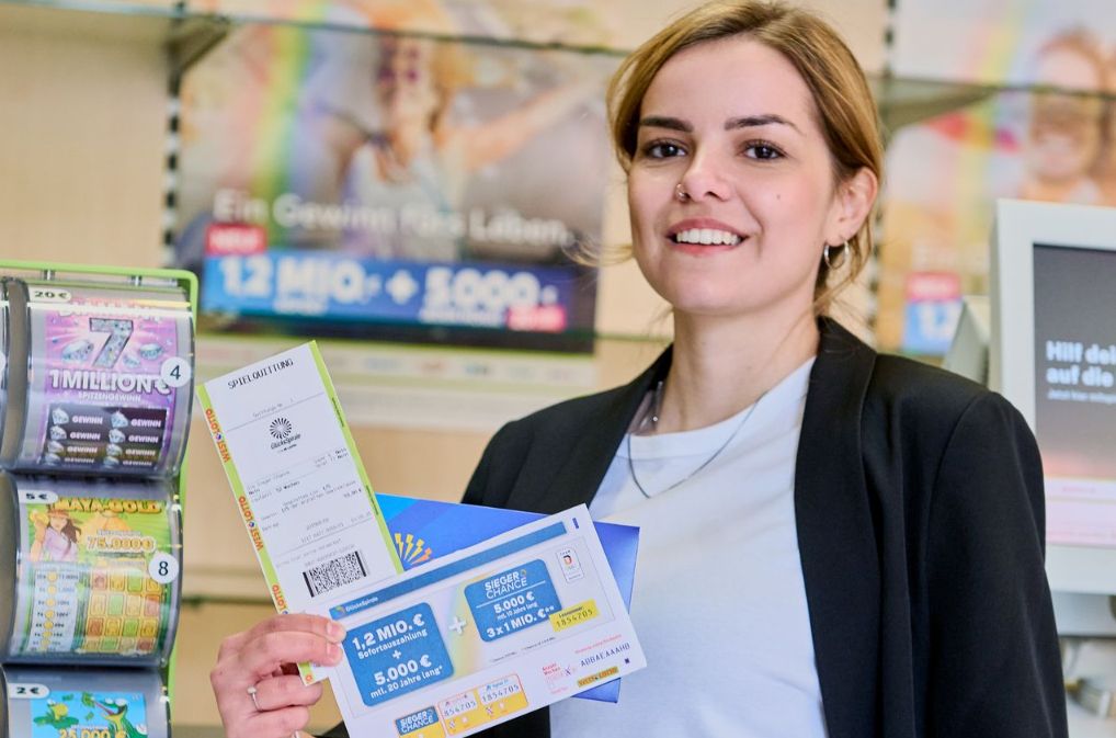 Eine Frau in einer WestLotto-Annahmestelle, die eine Spielquittung für ein Los der GlücksSpirale in der Hand hält.