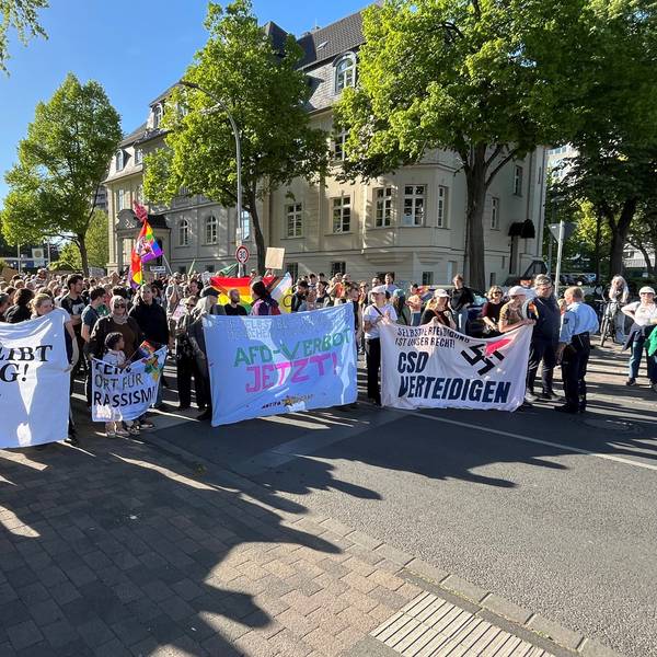 Zu sehen sind Demonstranten, sie halten Banner hoch.