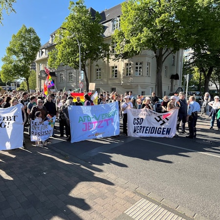 Zu sehen sind Demonstranten, sie halten Banner hoch.