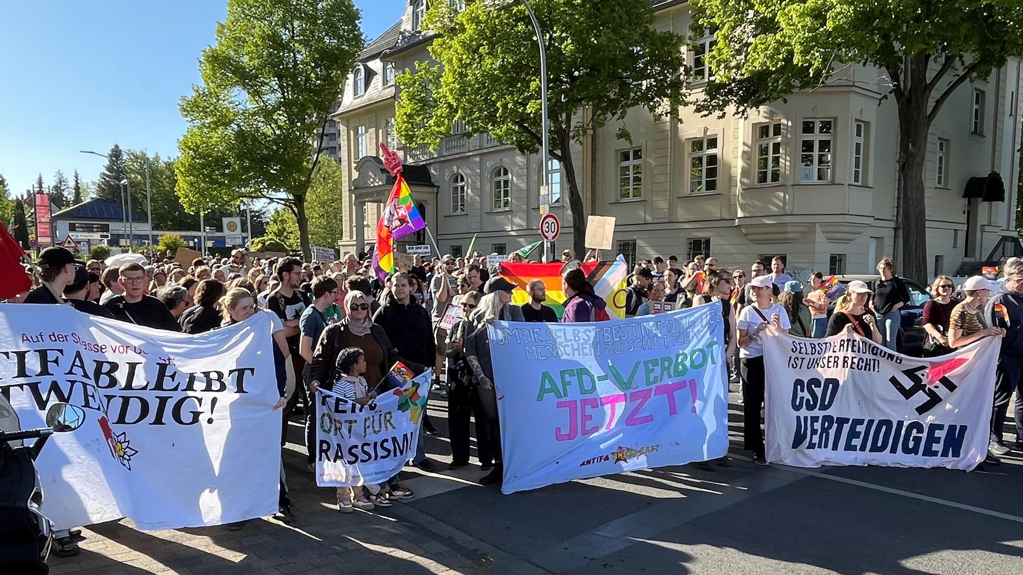Zu sehen sind Demonstranten, sie halten Banner hoch.
