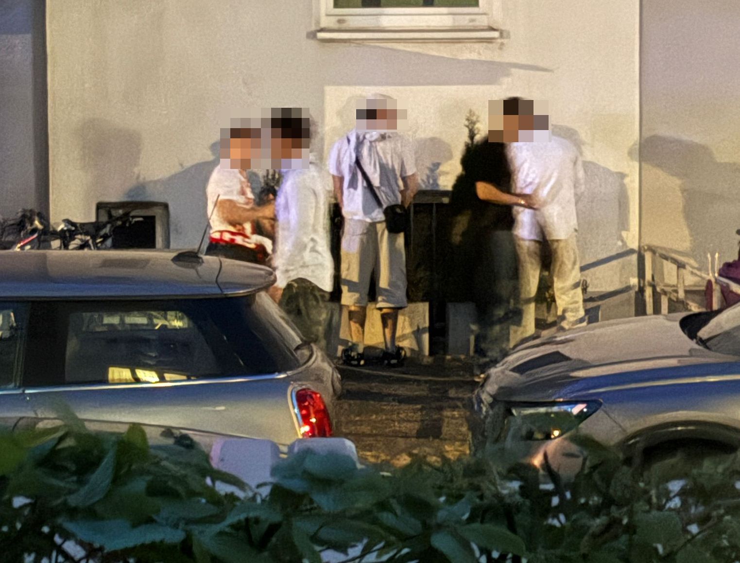 Junge Männer stehen an einer Häuserwand und erleichtern sich.