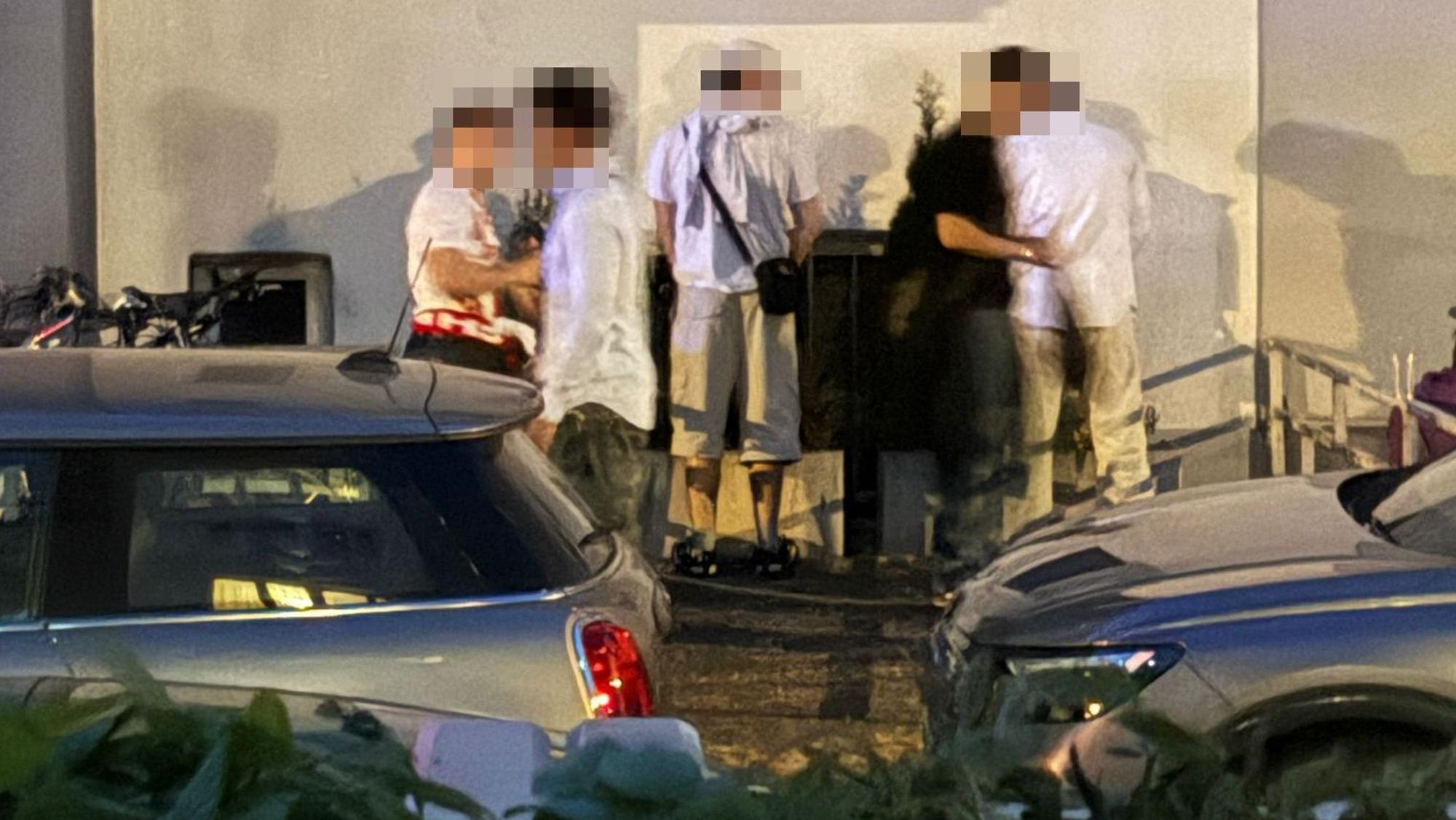 Junge Männer stehen an einer Häuserwand und erleichtern sich.