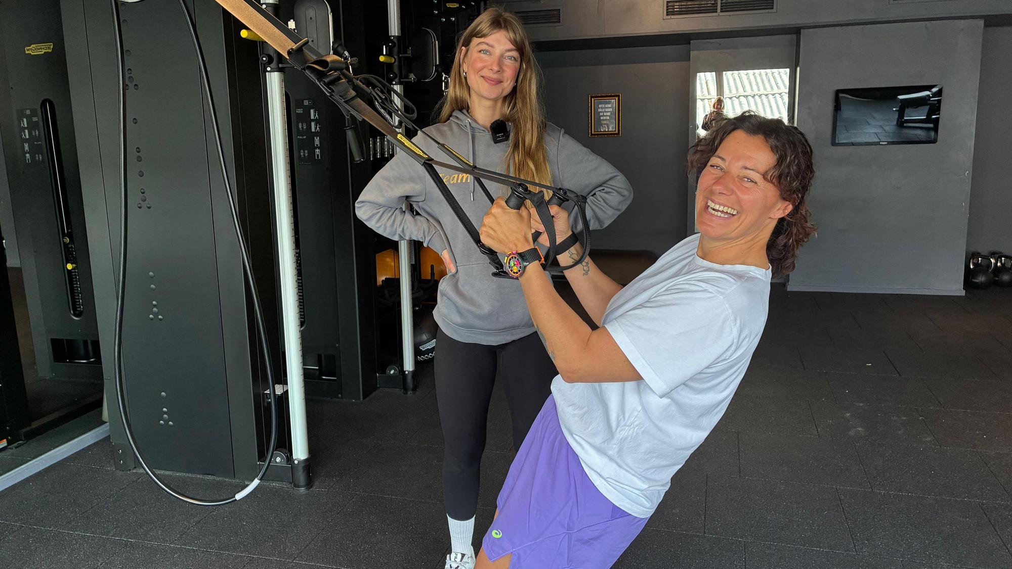 Zwei Frauen trainieren am Slingtrainer.