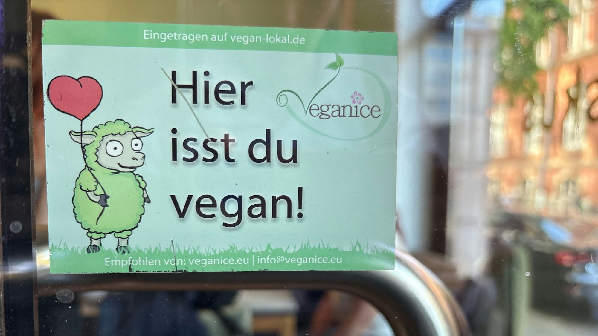 Schild, auf dem angekündigt wird, dass es veganes Essen im Café Hibiskus gibt.