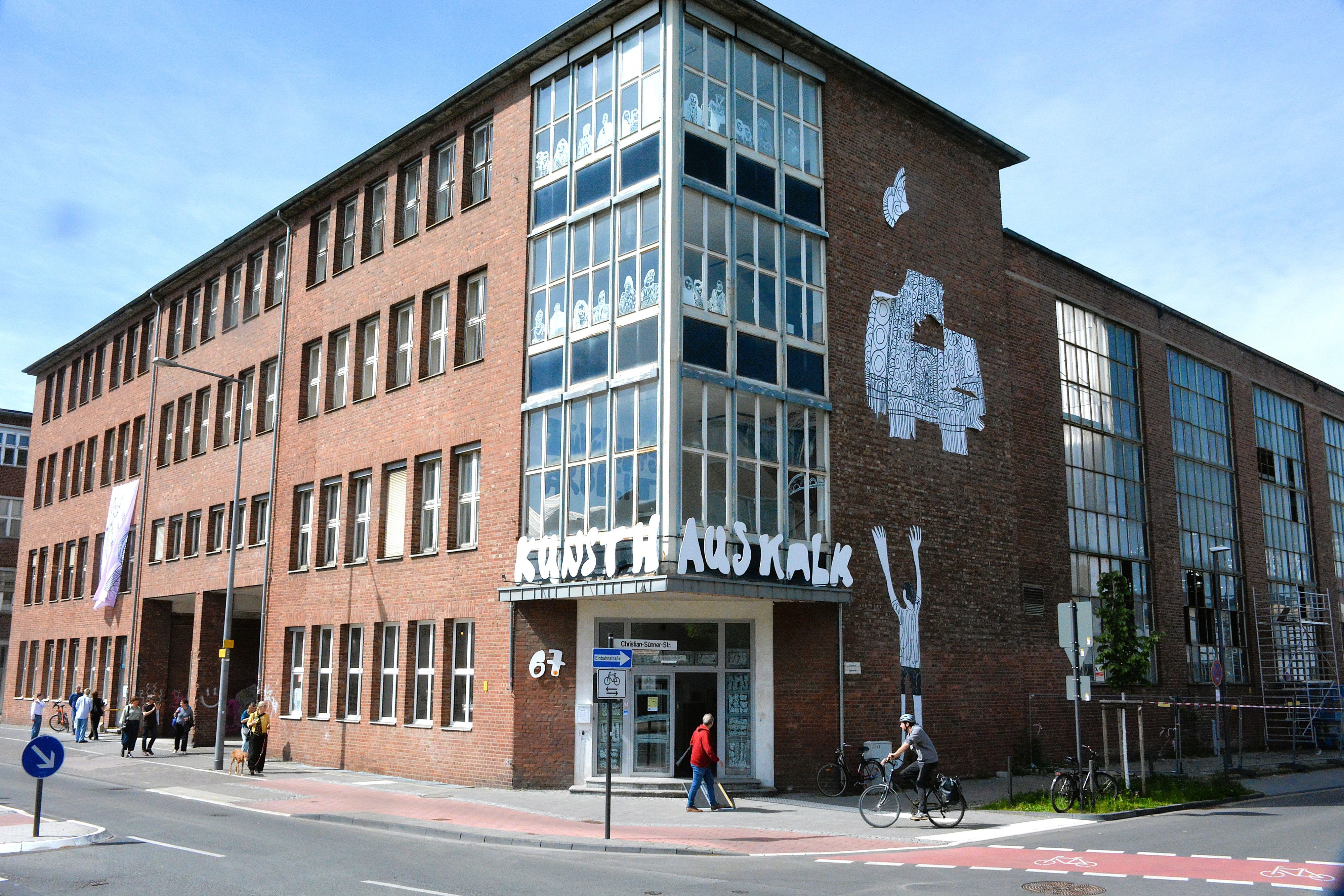 Zu sehen ist ein Backsteingebäude mit Kunstwerken an der Fassade.