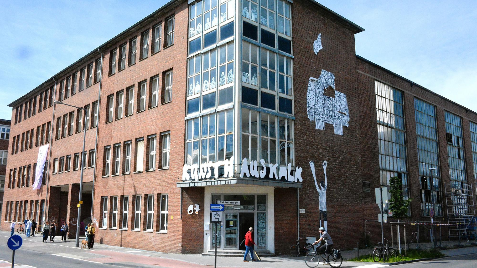 Zu sehen ist ein Backsteingebäude mit Kunstwerken an der Fassade.