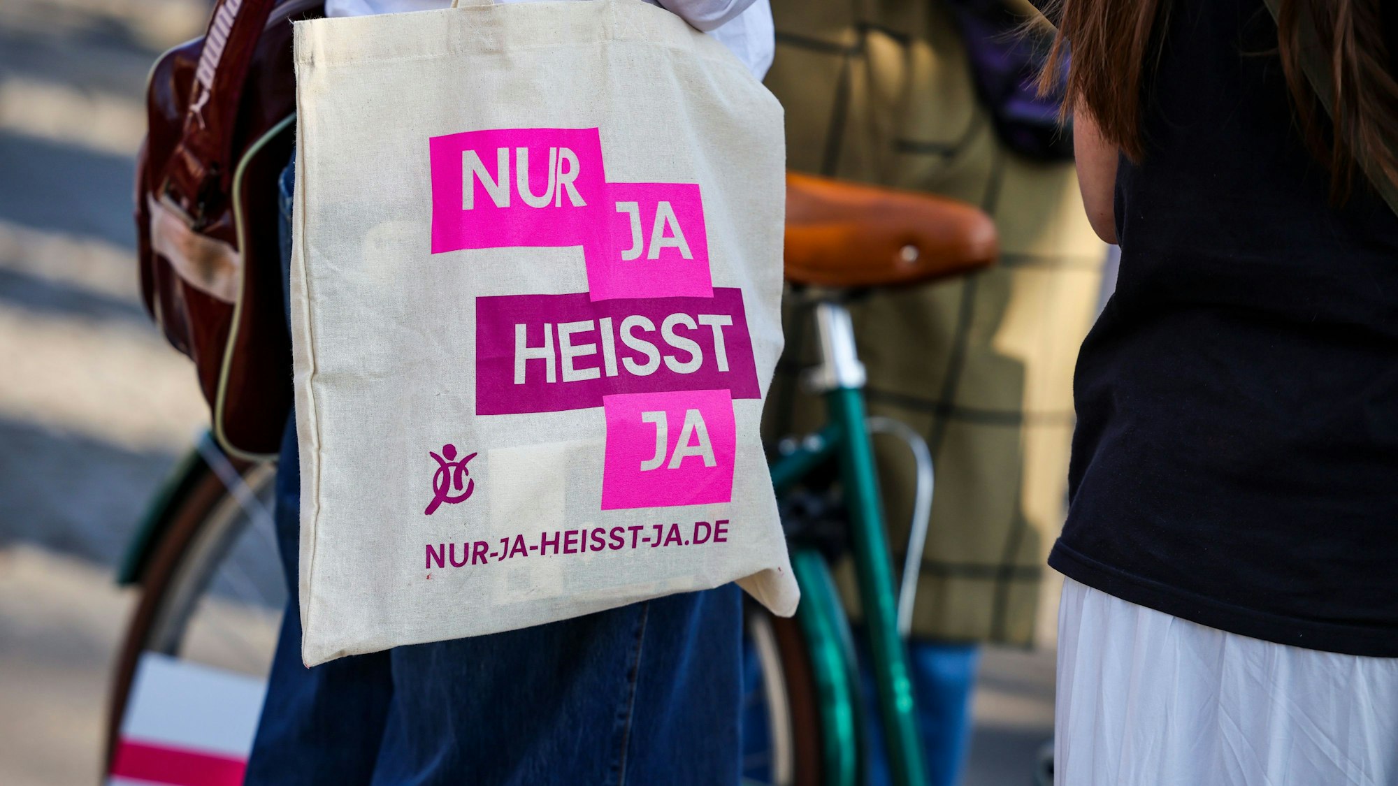 Bei einer Demo in Köln zum Internationalen Frauentag trägt eine Teilnehmerin eine Stofftasche mit der Aufschrift „Nur Ja heißt Ja“. (Archivbild)