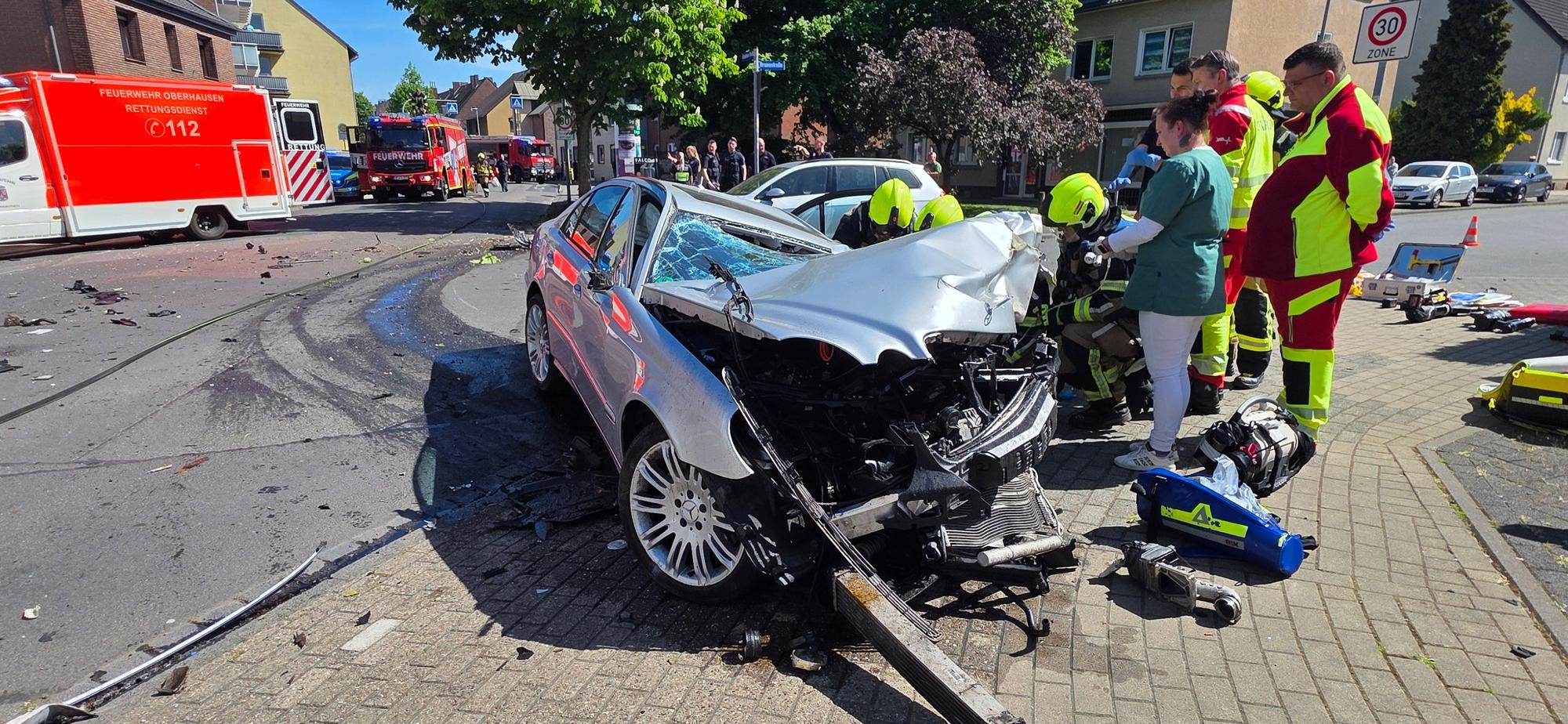 Die Feuerwehr am Unfallort vor dem völlig zerstörten Mercedes.