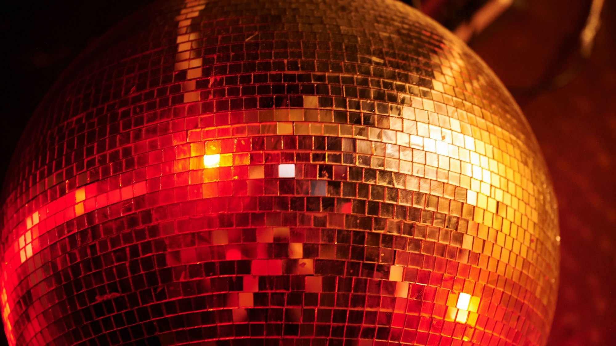 Eine Diskokugel leuchtet im Club.