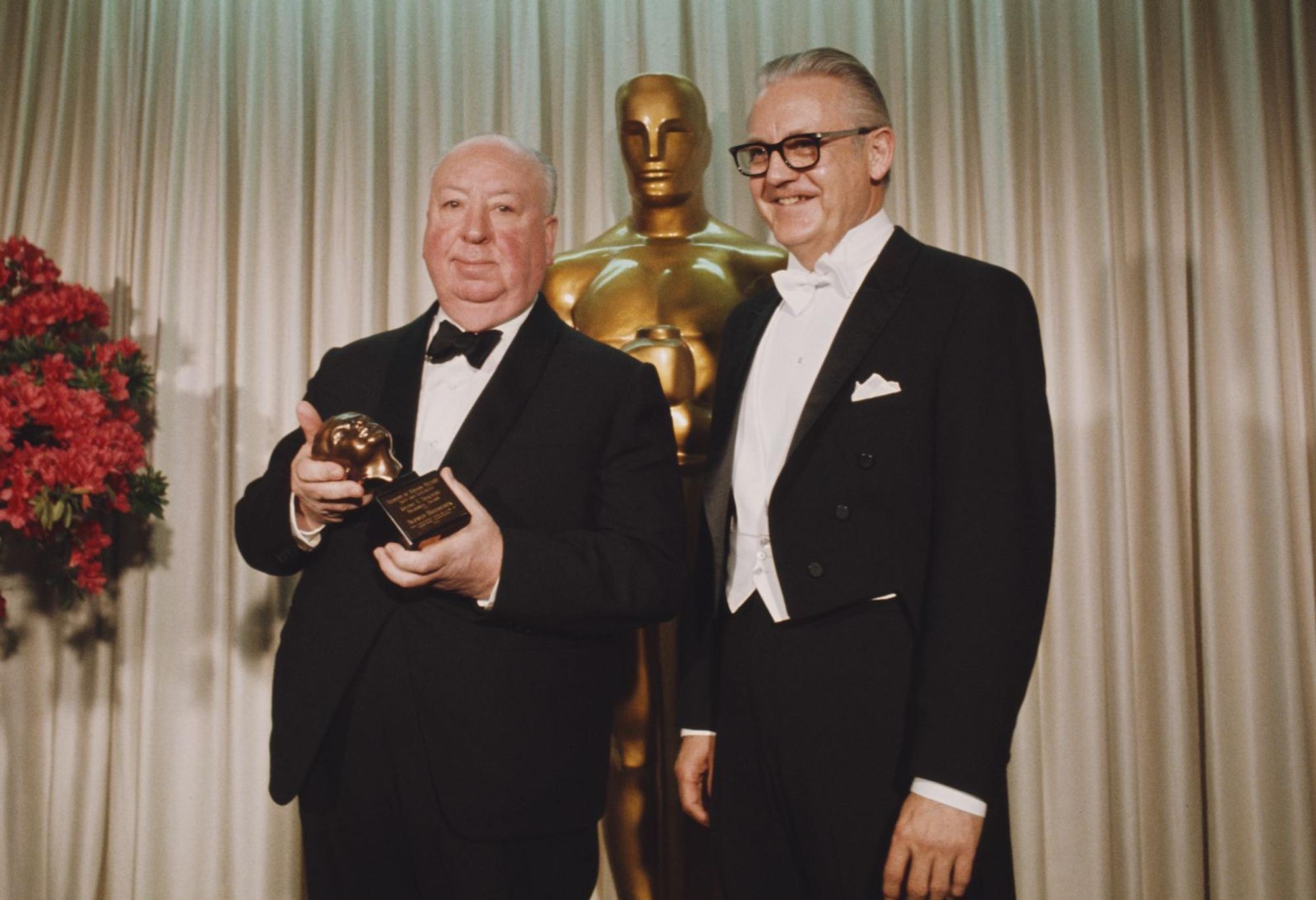 Alfred Hitchcock (links, mit Regisseur Robert Wise) erhielt nie den Regie-Oscar. 1968 bekam er lediglich den Ehrenoscar - den Irving G. Thalberg Memorial Award. „Thank you ... very much indeed“ - mit dieser kurzen Ansprache bedankte er sich bei der Oscar-Akademie. (Bild: Rolls Press/Popperfoto via Getty Image)