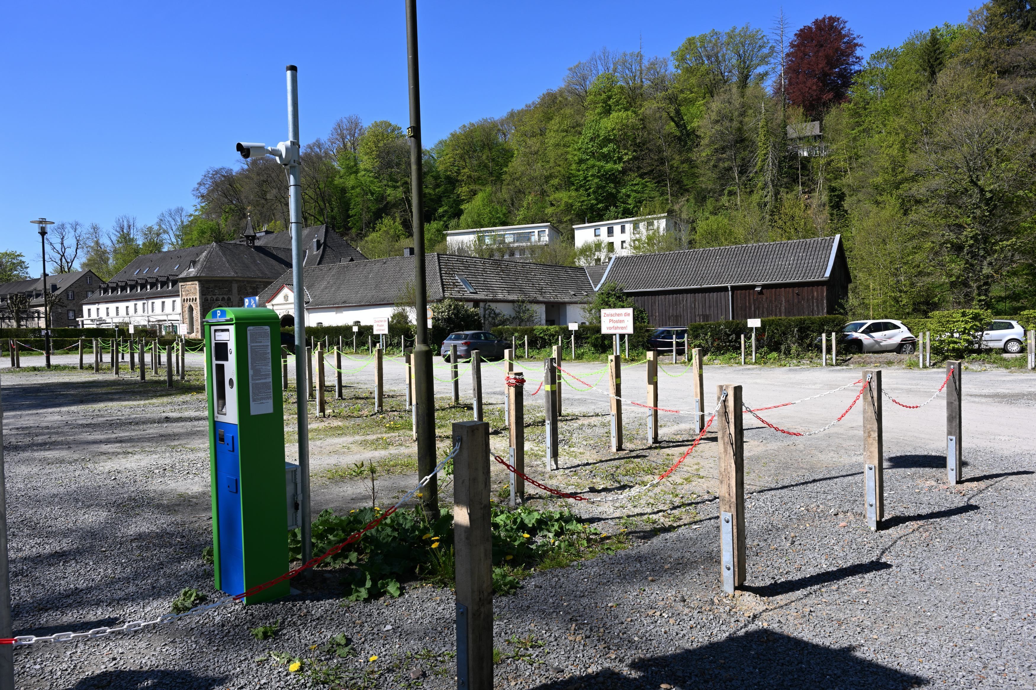 Ein Schotterparkplatz mit Kamera und Parkautomat.