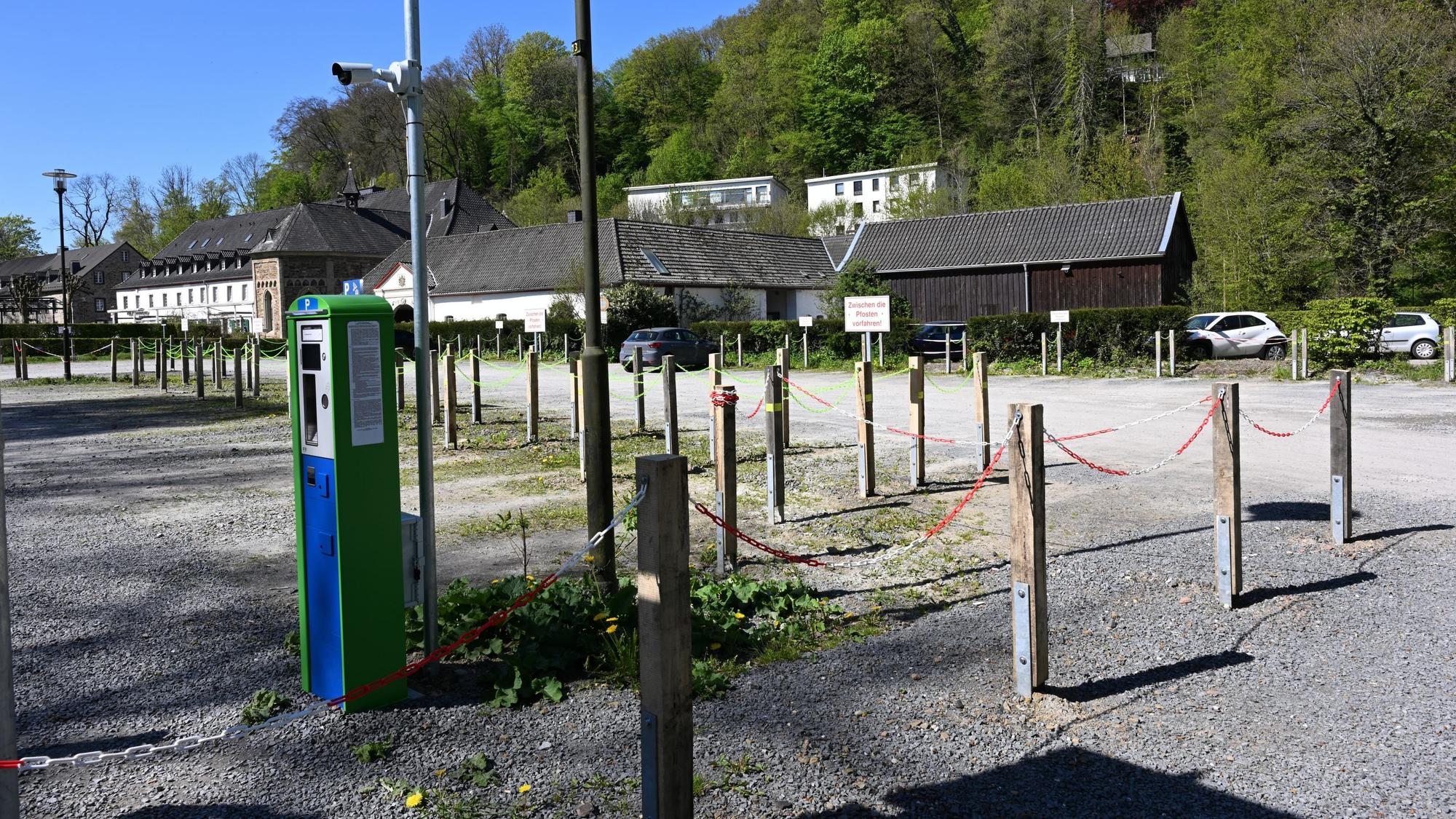 Ein Schotterparkplatz mit Kamera und Parkautomat.