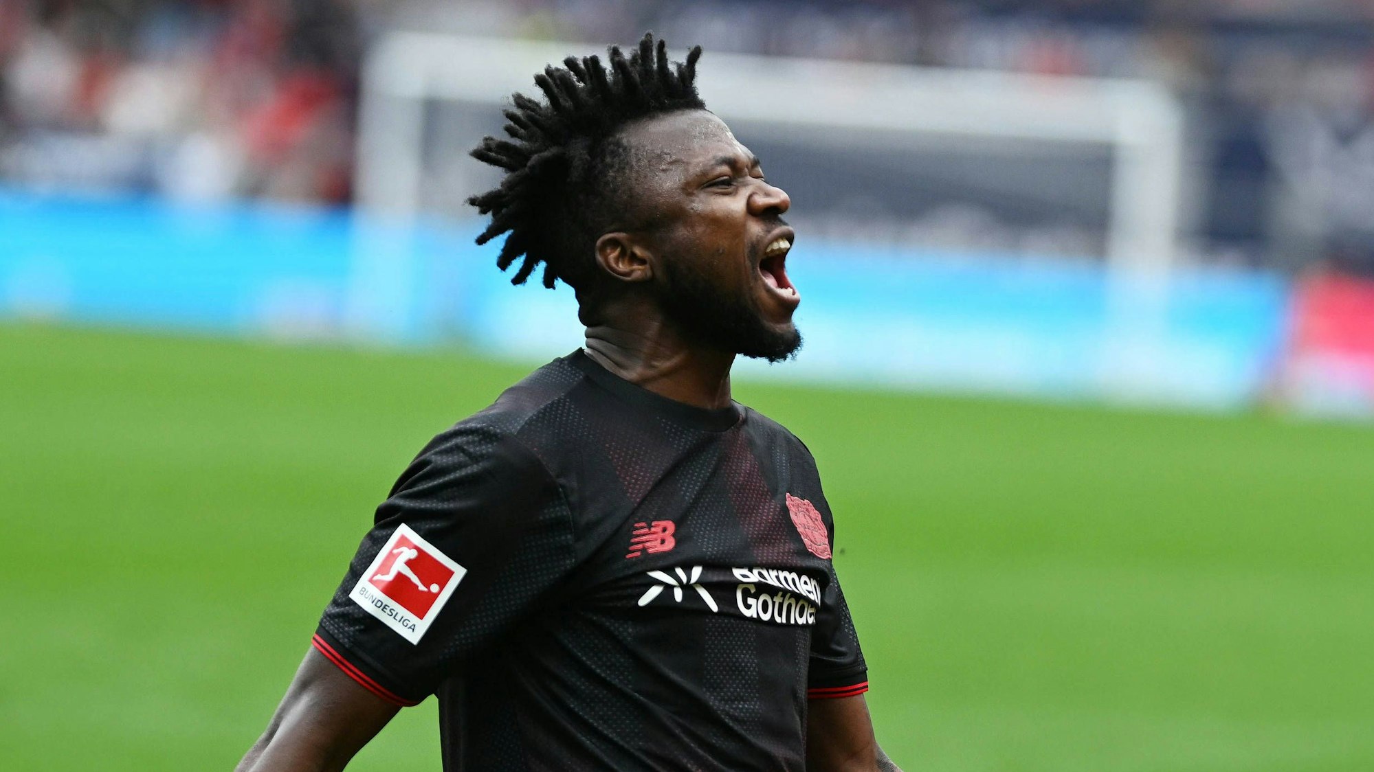 Edmond Tapsoba jubelt im Trikot von Bayer Leverkusen.