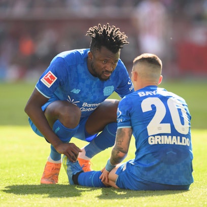 Alex Grimaldo Bayer Leverkusen sitzt am Boden, Edmond Tapsoba Bayer Leverkusen sieht nach ihm, Verletzung. Fussball 1. Bundesliga, 31.Spieltag, 1. FC Koeln - Bayer 04 Leverkusen. 1:2, am 25.04.2026 in Koeln/ Deutschland. DFL regulations prohibit any use of photographs as image sequences and/or quasi-video  *** Alex Grimaldo Bayer Leverkusen sits on the ground, Edmond Tapsoba Bayer Leverkusen looks after him, injury Football 1 Bundesliga, Matchday 31, 1 FC Koeln Bayer 04 Leverkusen 1 2, on 25 04 2026 in Koeln Germany DFL regulations prohibit any use of photographs as image sequences and or quasi video Â
