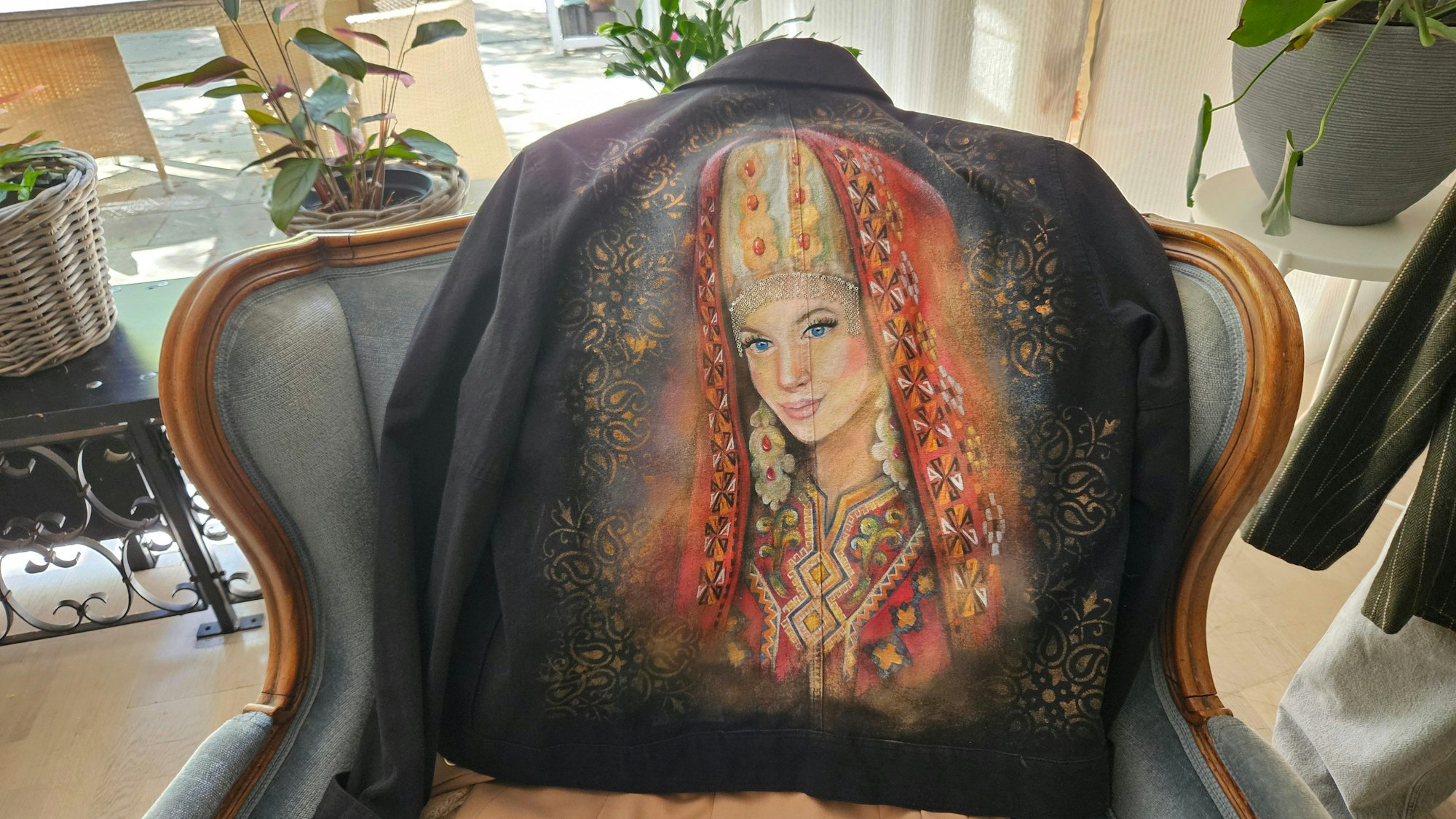 Das Foto zeigt eine Jacke, auf der eine Frau in Tracht abgebildet ist.