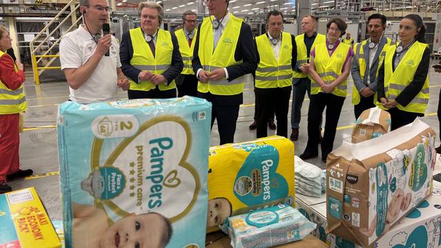Hendrik Wüst mit einer Besuchergruppe bei der Führung im Procter & Gamble-Werk Euskirchen.